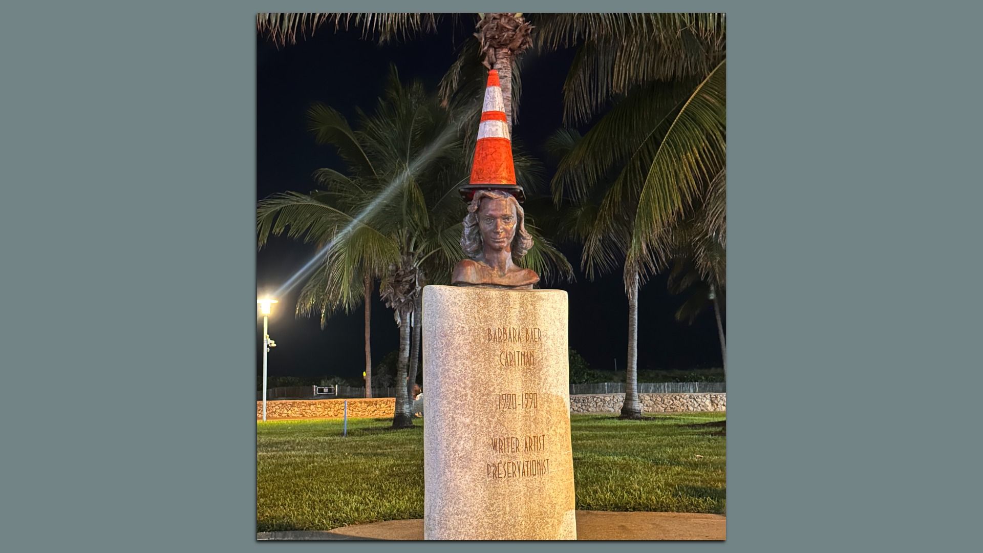 A statue of Barbara Baer Capitman in South Beach with a traffic cone on its head.