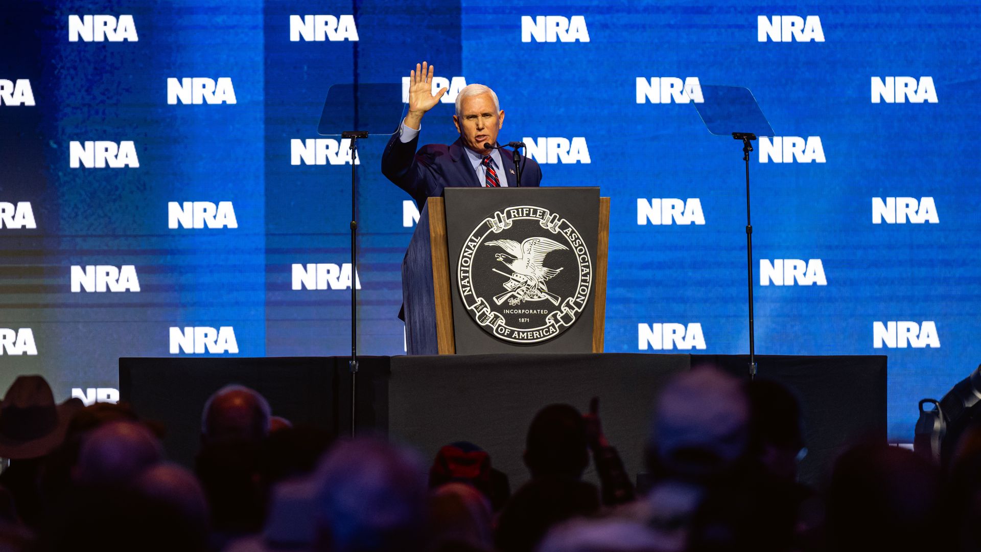 Former Vice President Mike Pence holds up his right hand while addressing the NRA convention in Indianapolis.