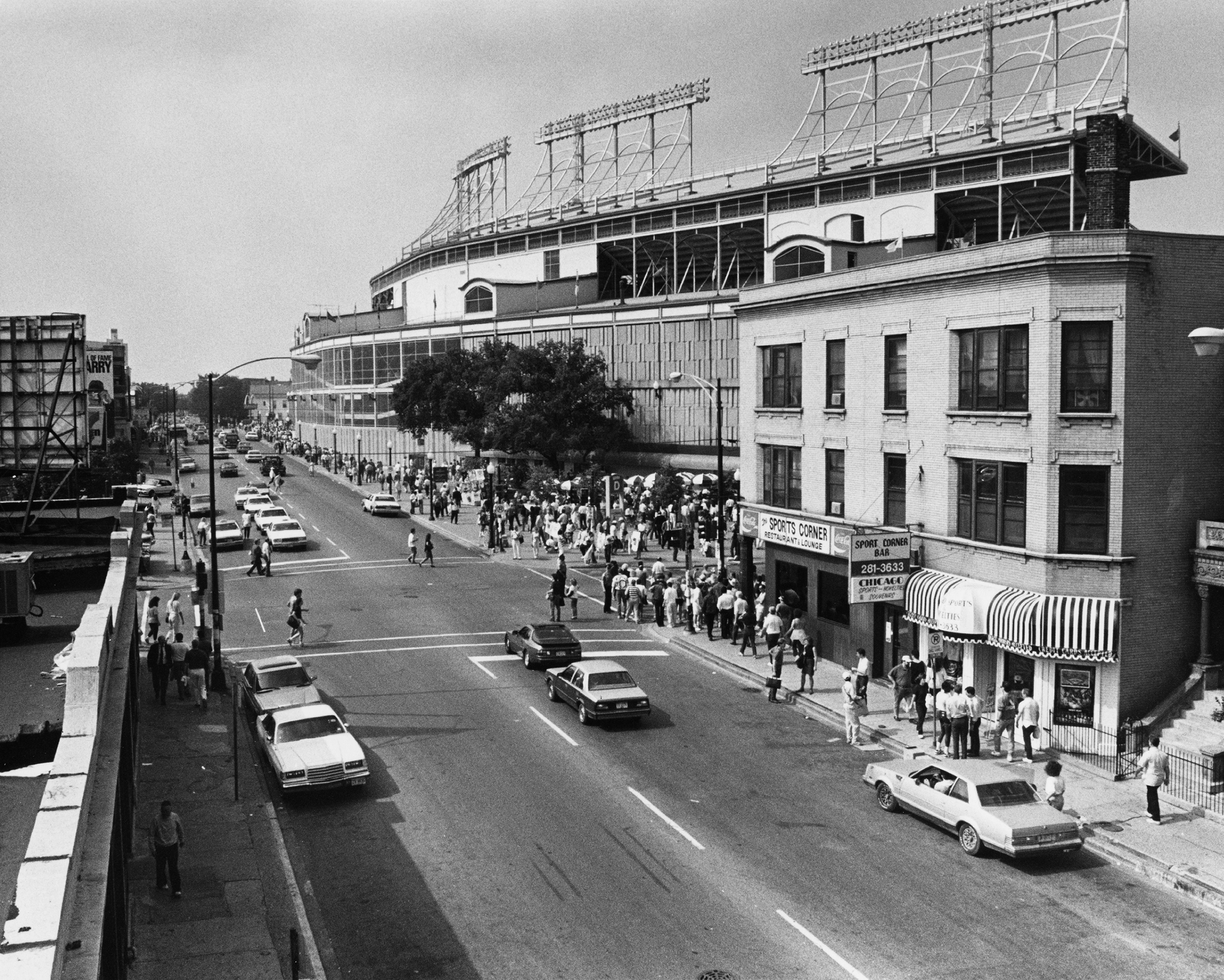 Photo of a street next to a ballpark in a neighborhood. 