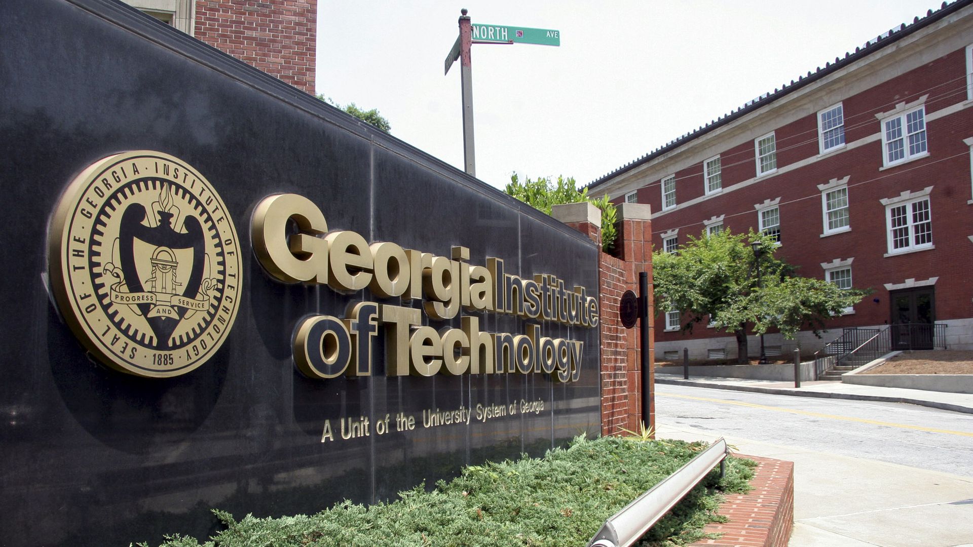 A black sign with gold lettering positioned at the entrance of the Georgia Tech campus.