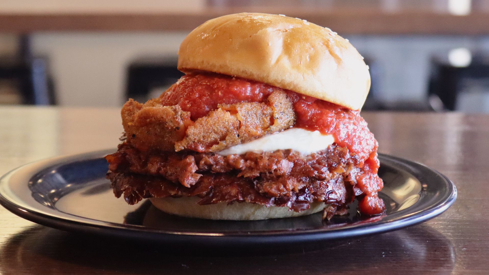 A burger with spaghetti toppings on top.