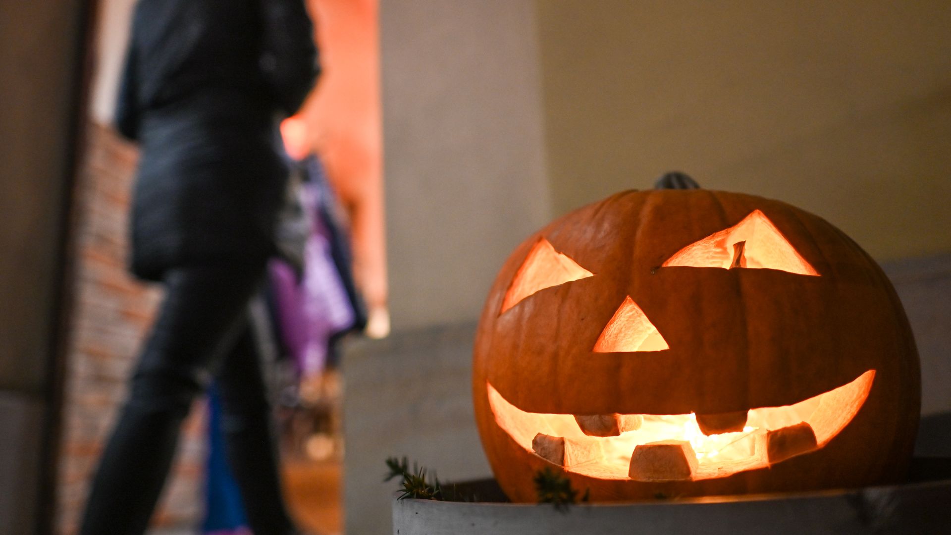 Light emits from a jack-o'-lantern sitting on a porch during Halloween 