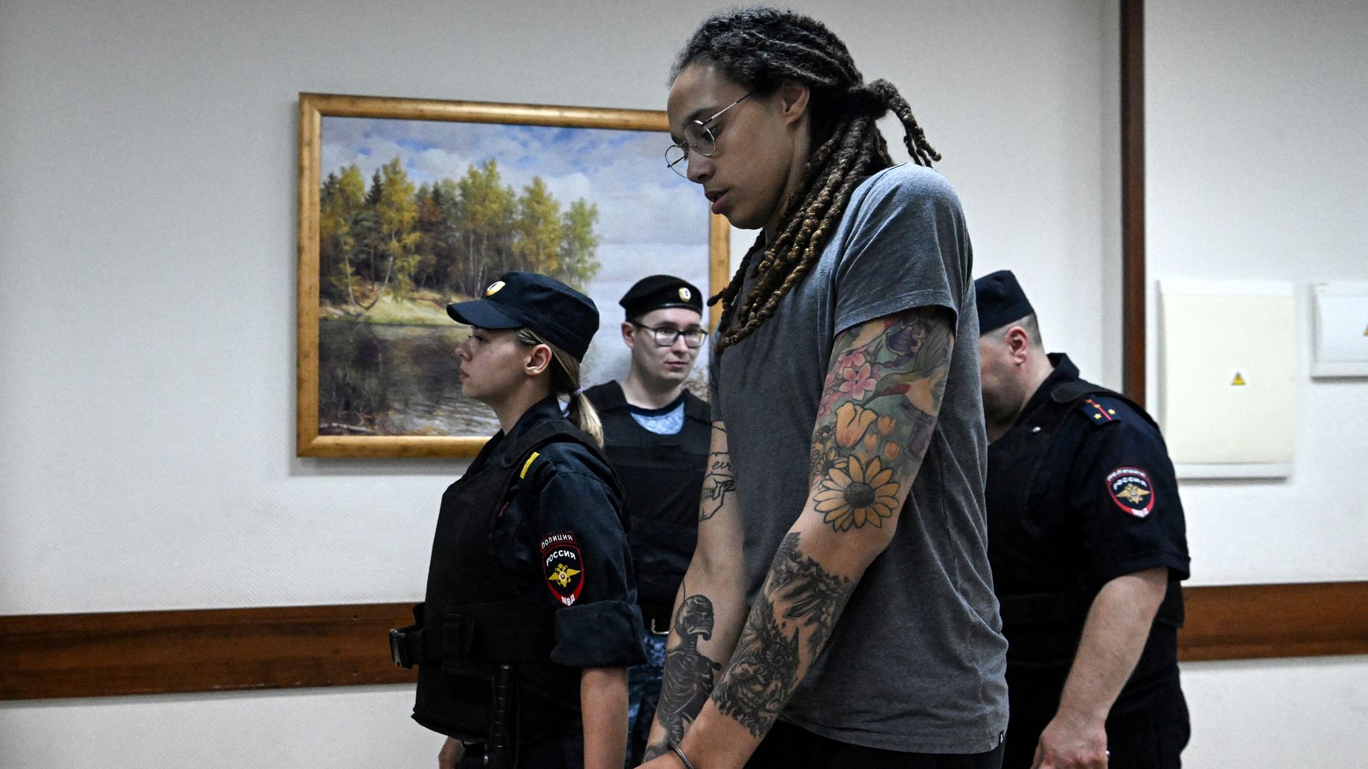 Photo of Brittney Griner in handcuffs and escorted by prison guards