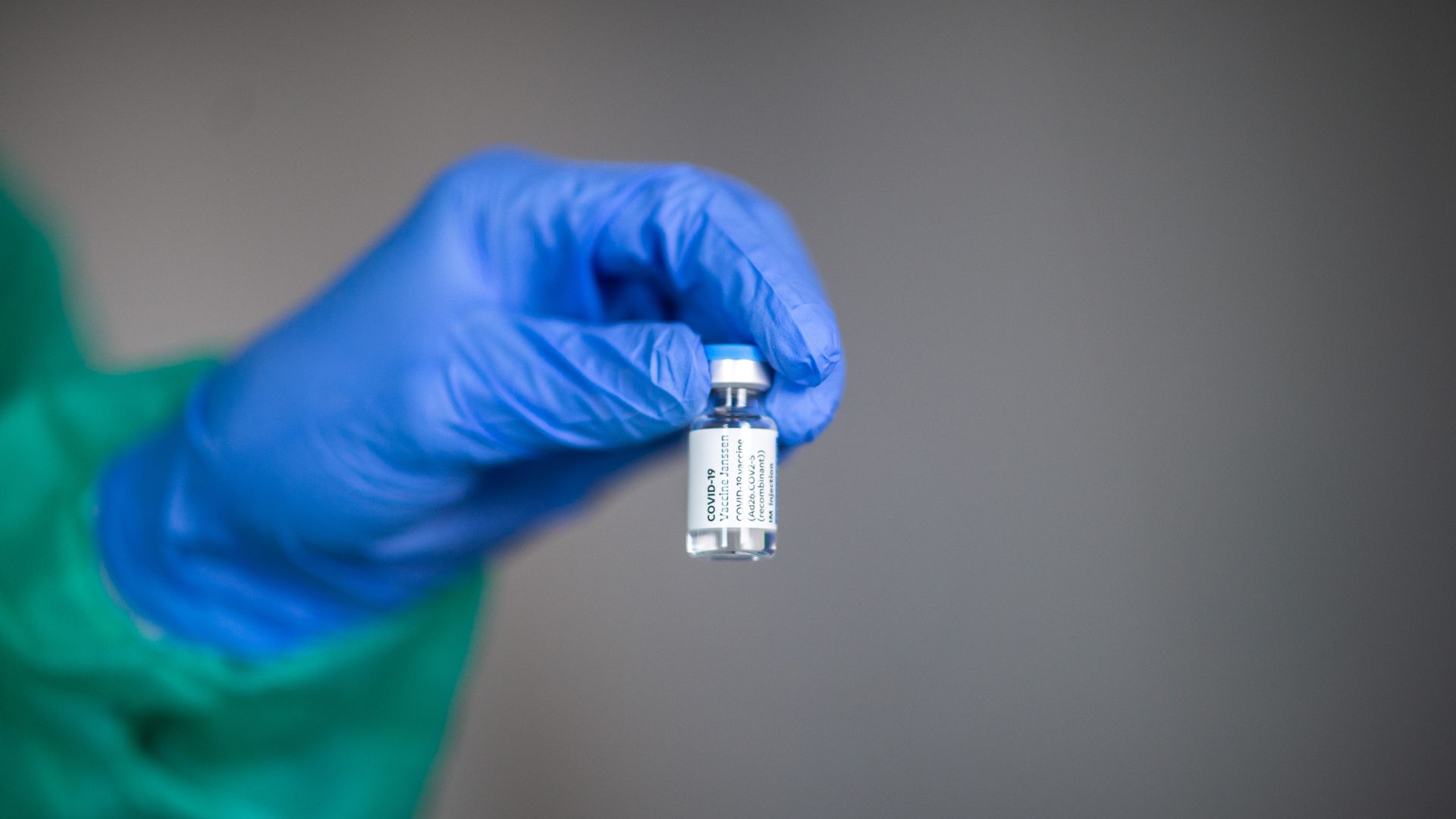 Picture of a hand holding a vial of the Johnson & Johnson vaccine