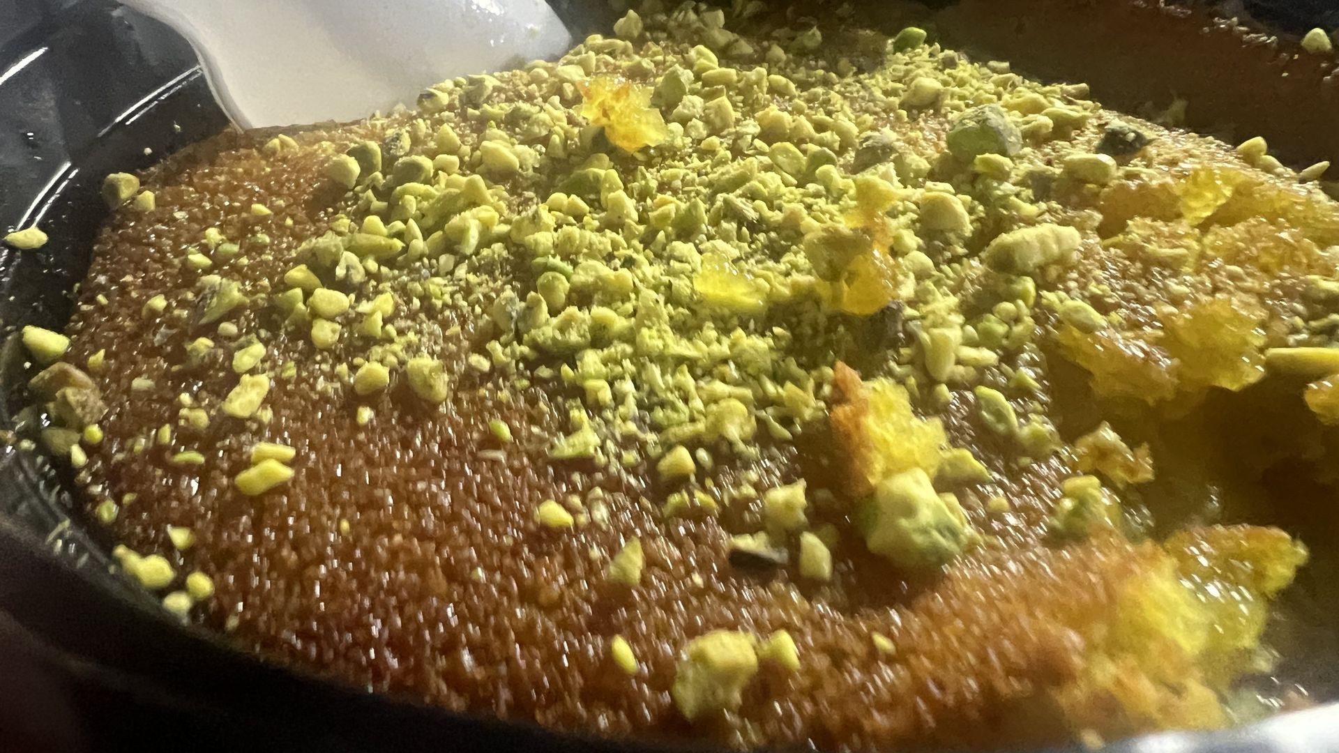 Close up photo of Kunafa, topped with pistachios. 