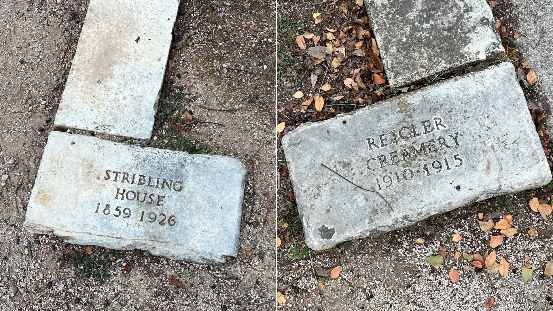 Two weathered stone markers on the ground with engraved text: one reads "STRIBLING HOUSE 1859 1926," the other "REIGLER CREAMERY 1910 1915" surrounded by dirt and fallen leaves.