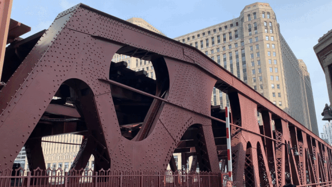 Photo of a train going over a bridge in the city