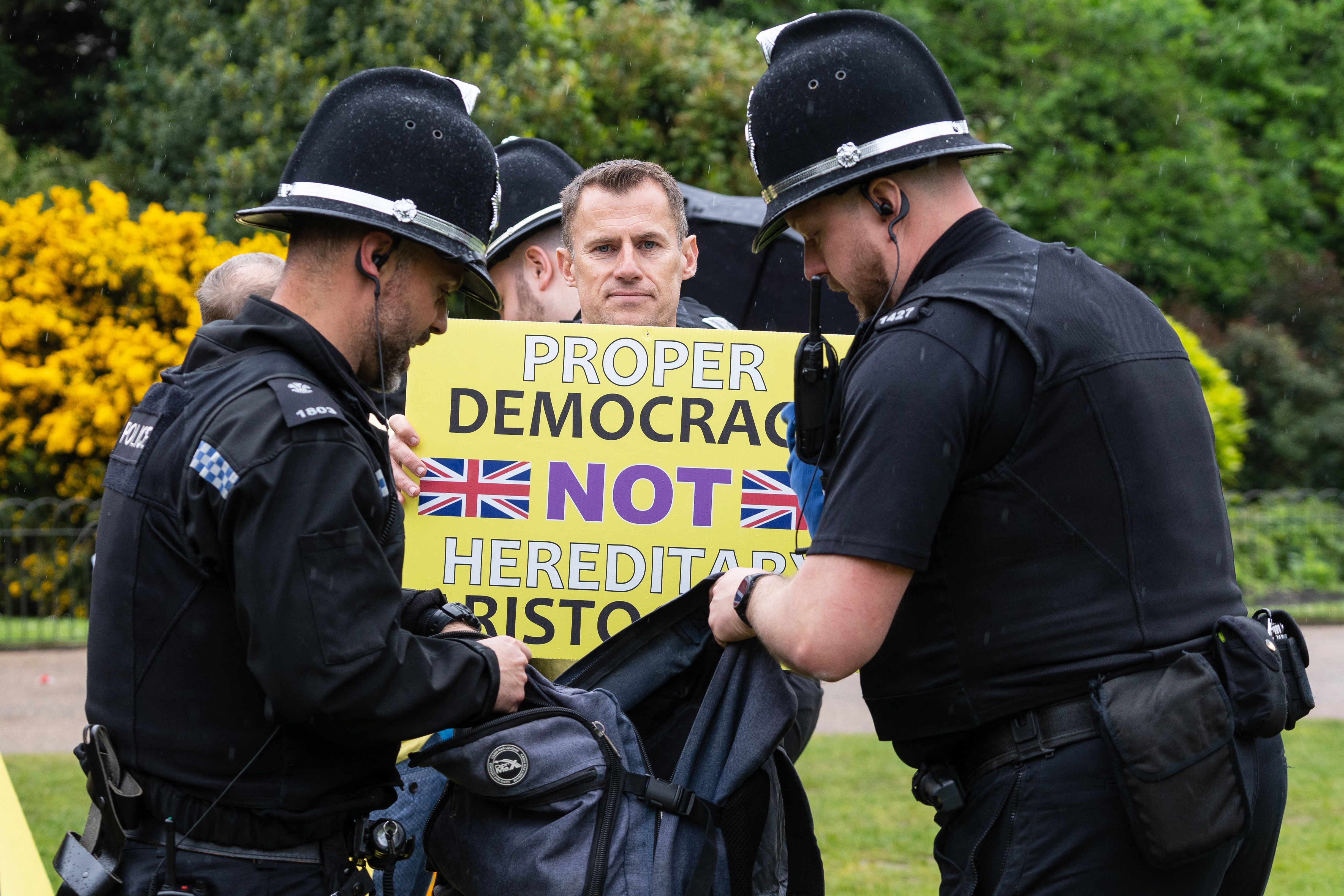 A member of the anti-monarchist group Republic is apprehended by police officers as they stage a protest close to where Britain's King Charles III 