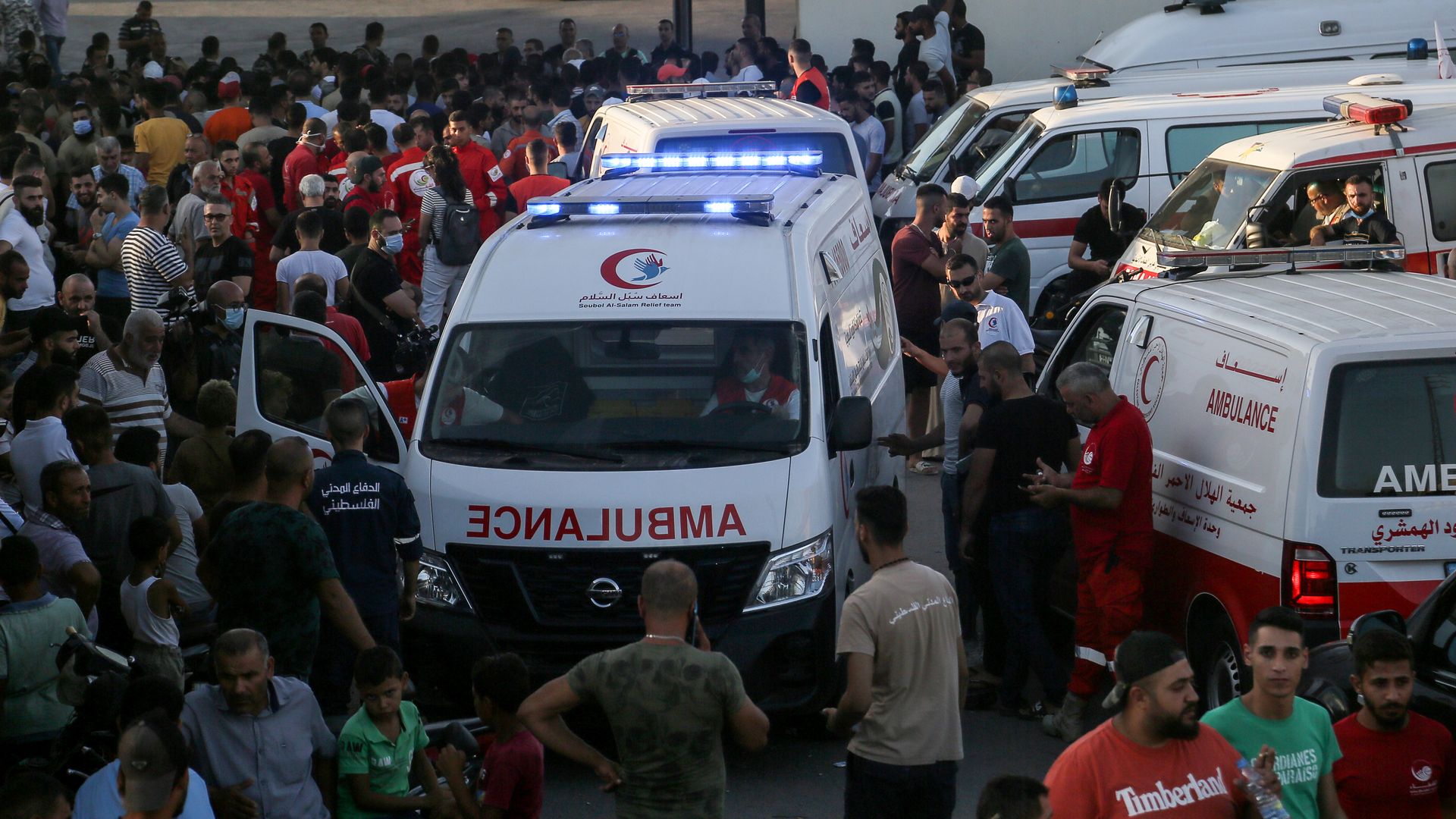 Ambulances wait for the arrival of Lebanese and Palestinian bodies who drowned when a boat carrying migrants sank off the Syrian coas