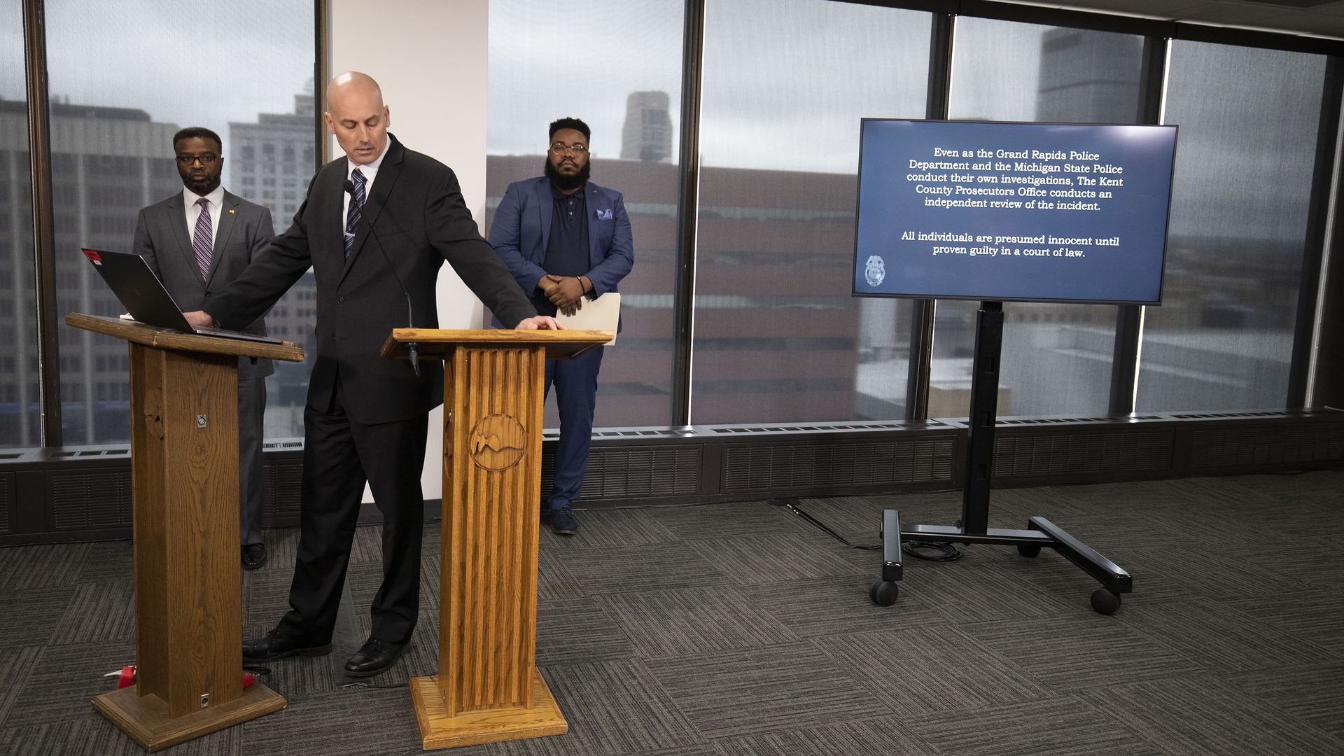 Grand Rapids City Manager Mark Washington, Grand Rapids Police Chief Eric Winstrom and Brandy Davis stand at a press conference.