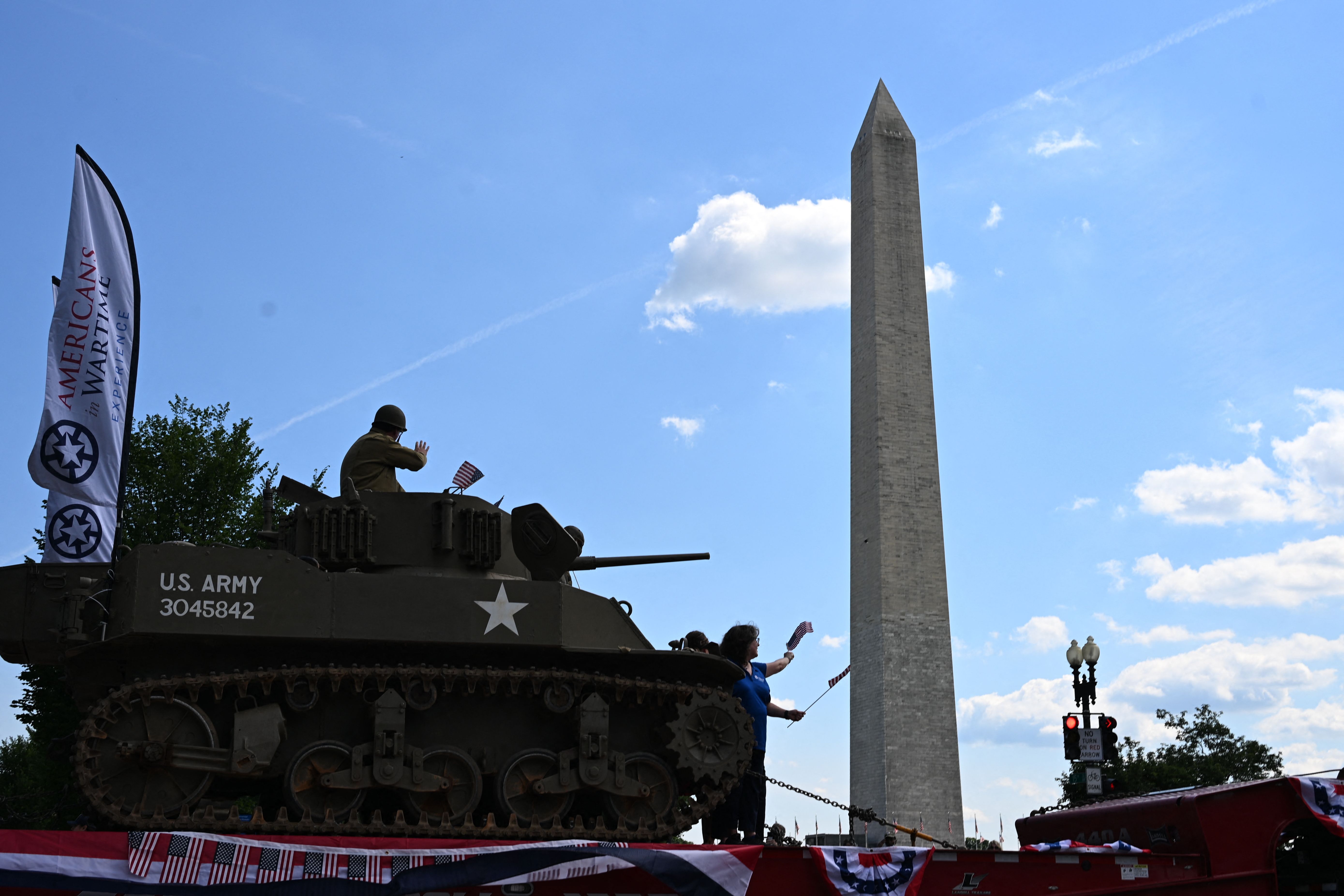 Military tank passes in front of D.C.'s Washington Monument