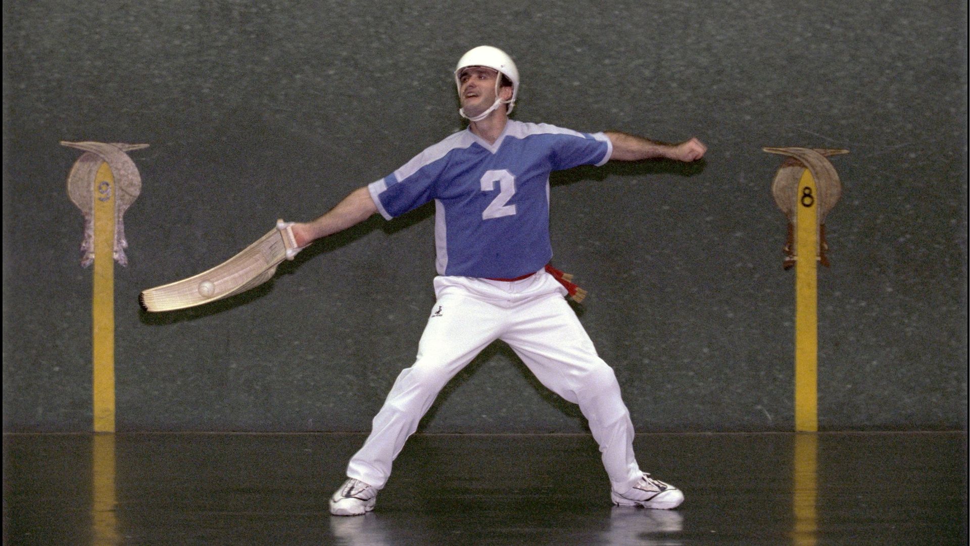A jai alai player with a wicker cesta.
