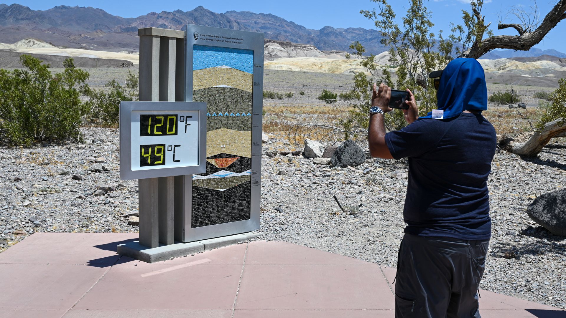 A man takes a photo of thermometer that shows 120 Fahrenheit (49 C) at the Furnace Creek Visitor Center in Death Valley today as extreme heat wave warming issued in California, United States on June 6, 2024.
