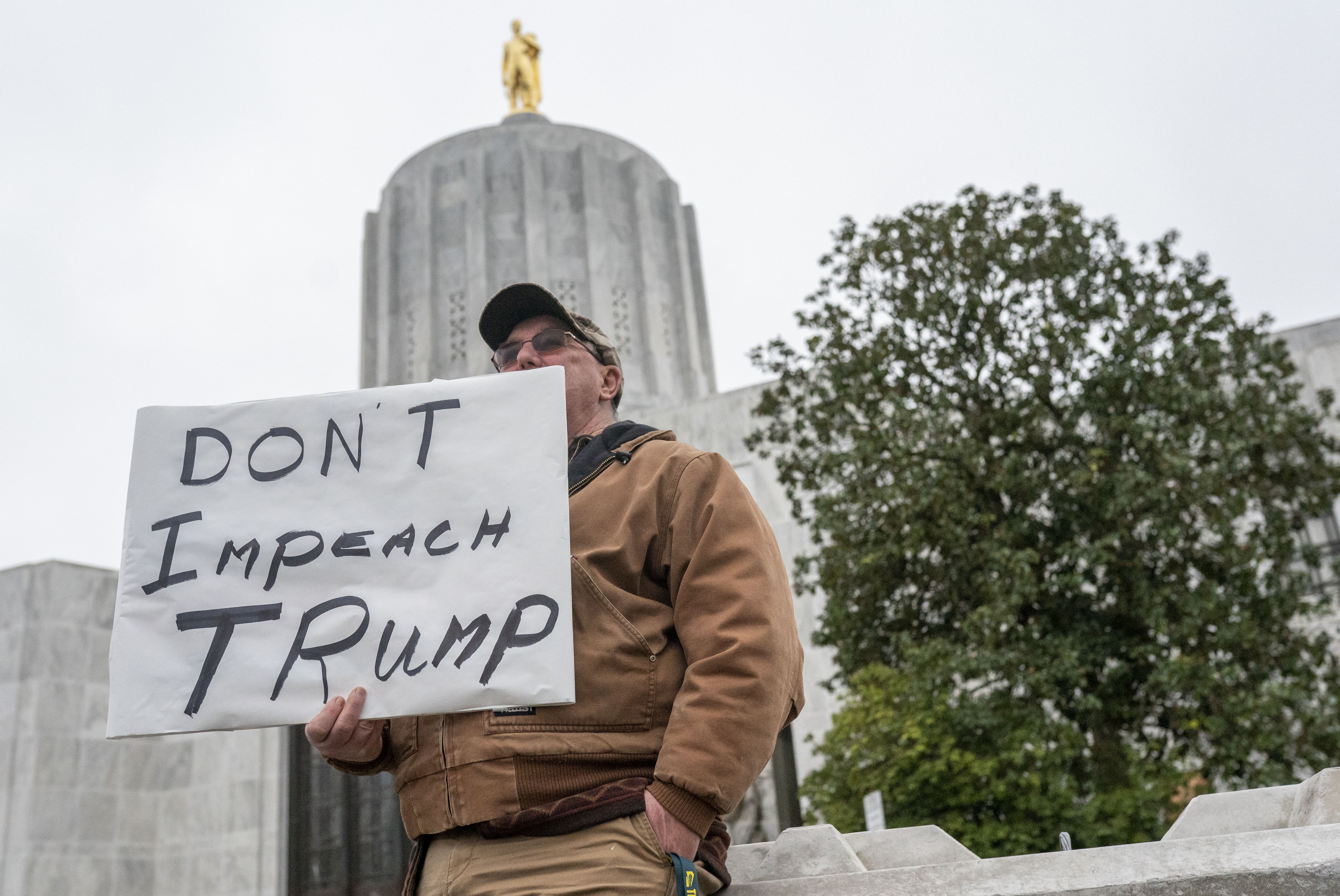 A single protester holds a sign protesting the second impeachment of President Trump at the location of a planed pro-Trump rally that didnt occur on January 16, 2021 in Salem, Oregon. 