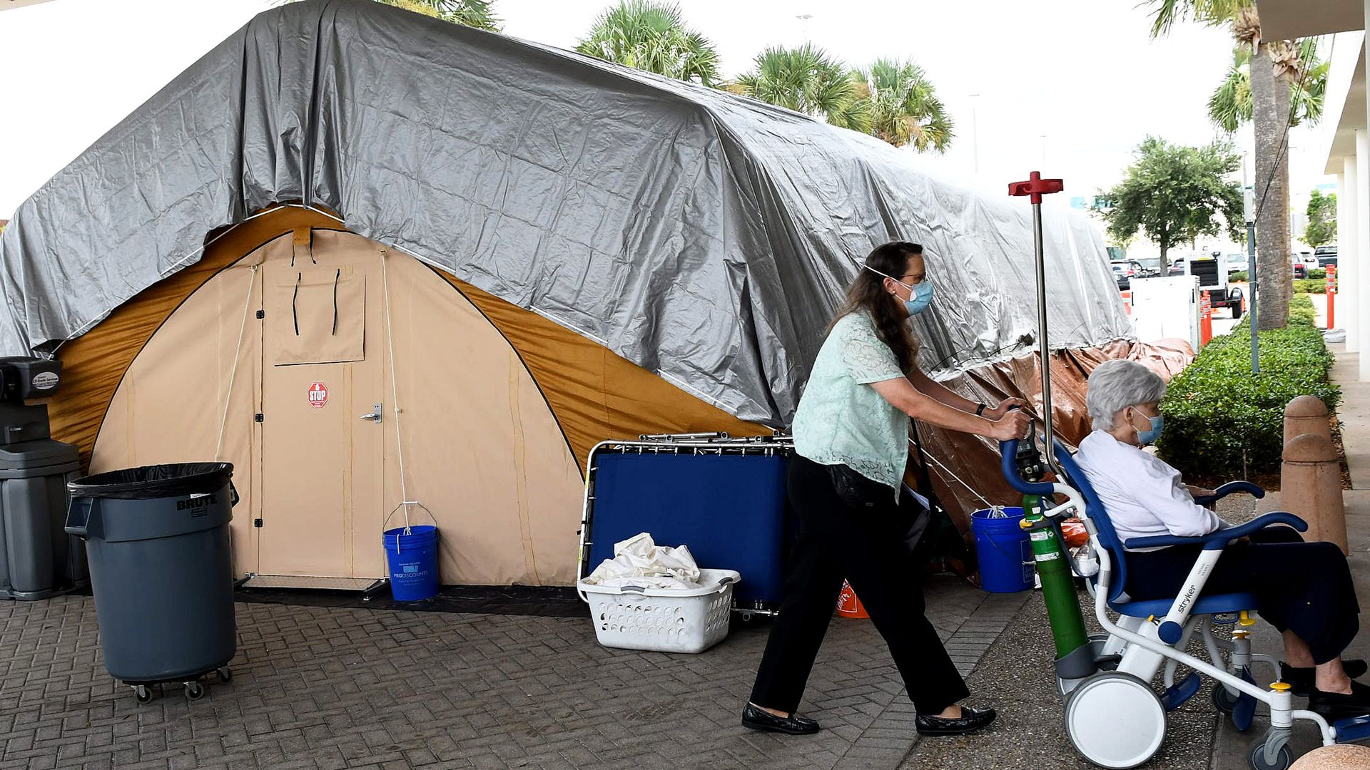 A patient is brought near a treatment tent outside the emergency department at Holmes Regional Medical Center in Melbourne.