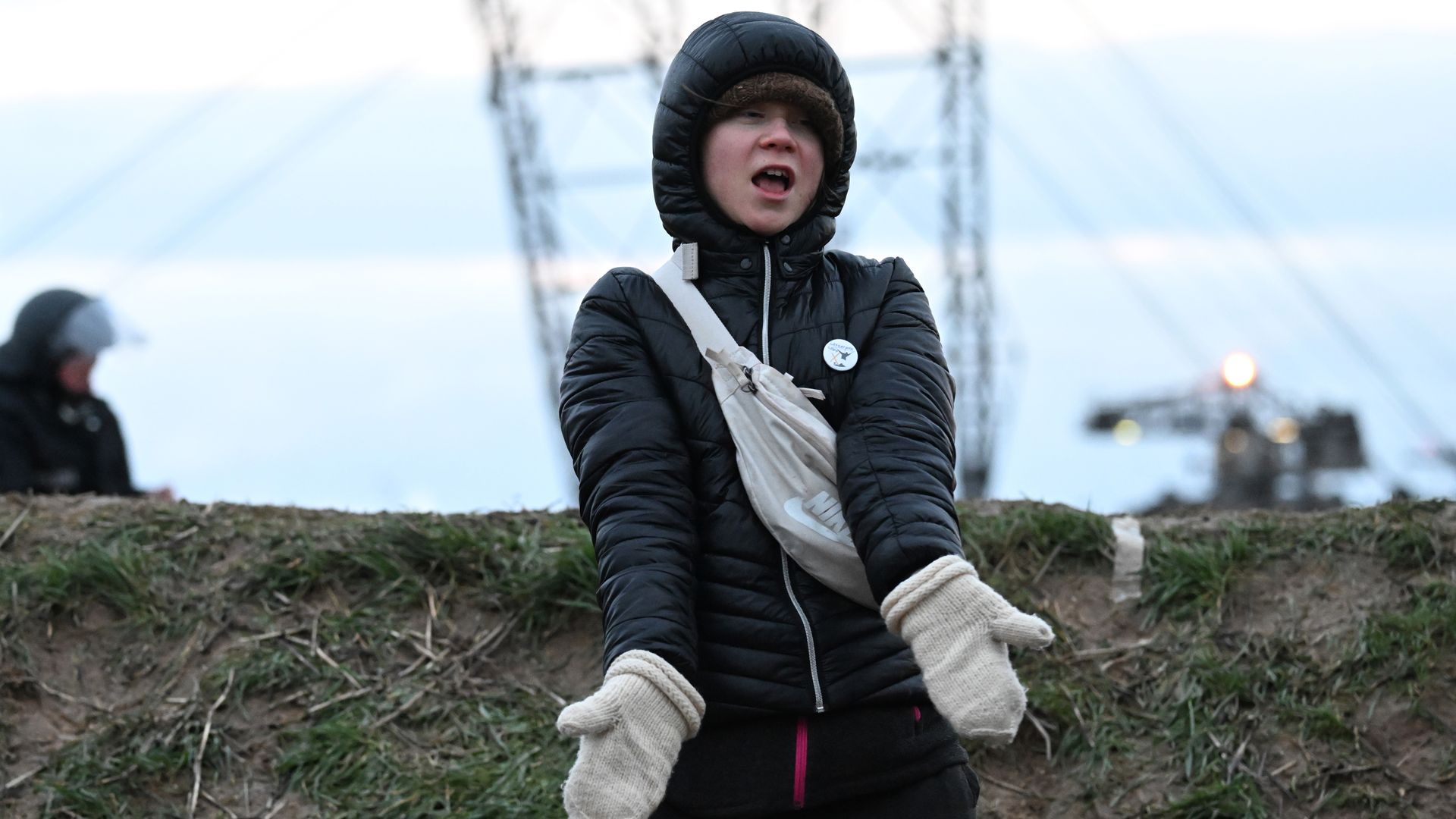 North Rhine-Westphalia, Erkelenz: Climate activist Greta Thunberg (r) stands between Keyenberg and Lützerath under police guard on the edge of the open pit mine and dances. 