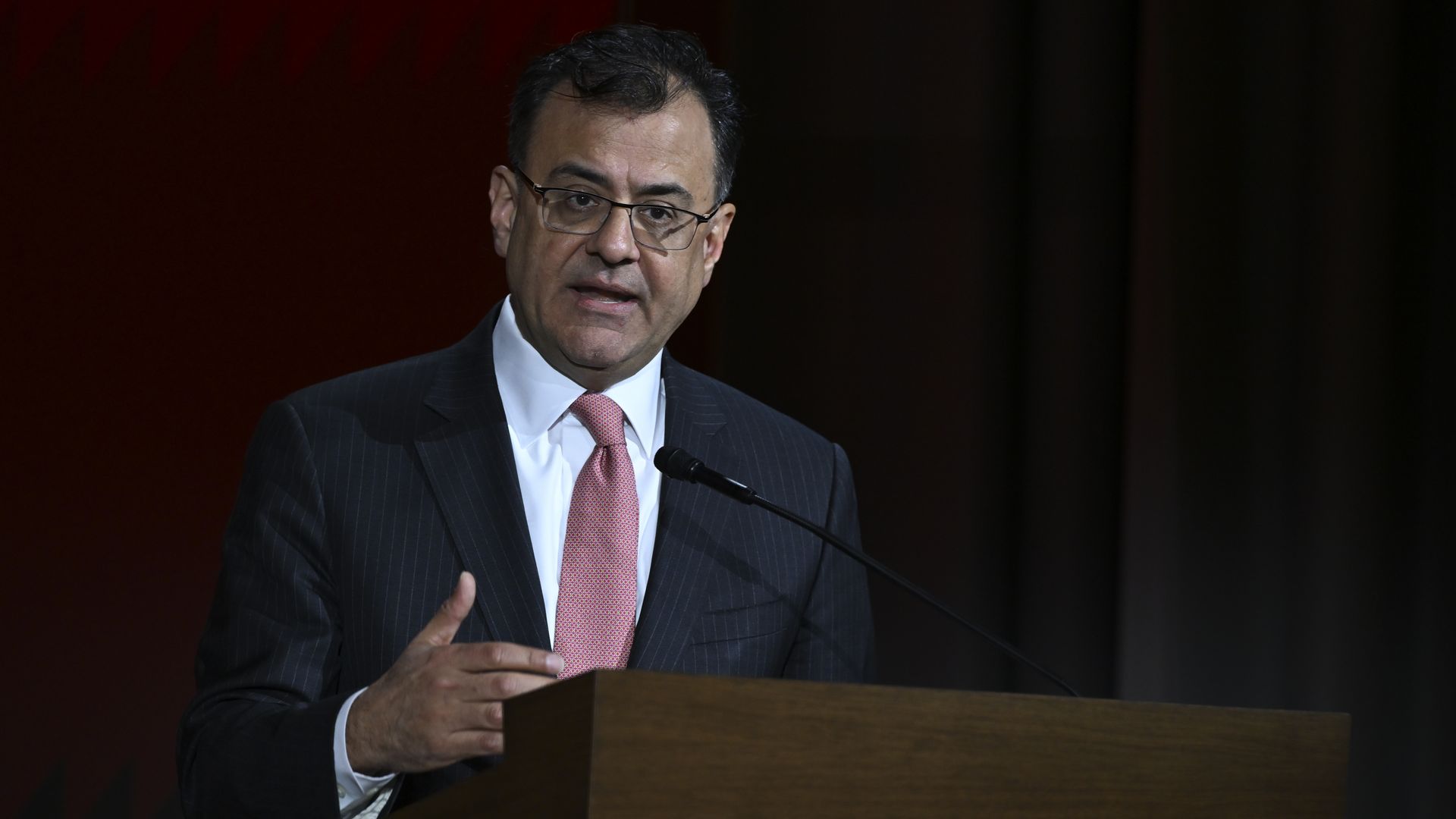 A person stands at a podium in front of a microphone