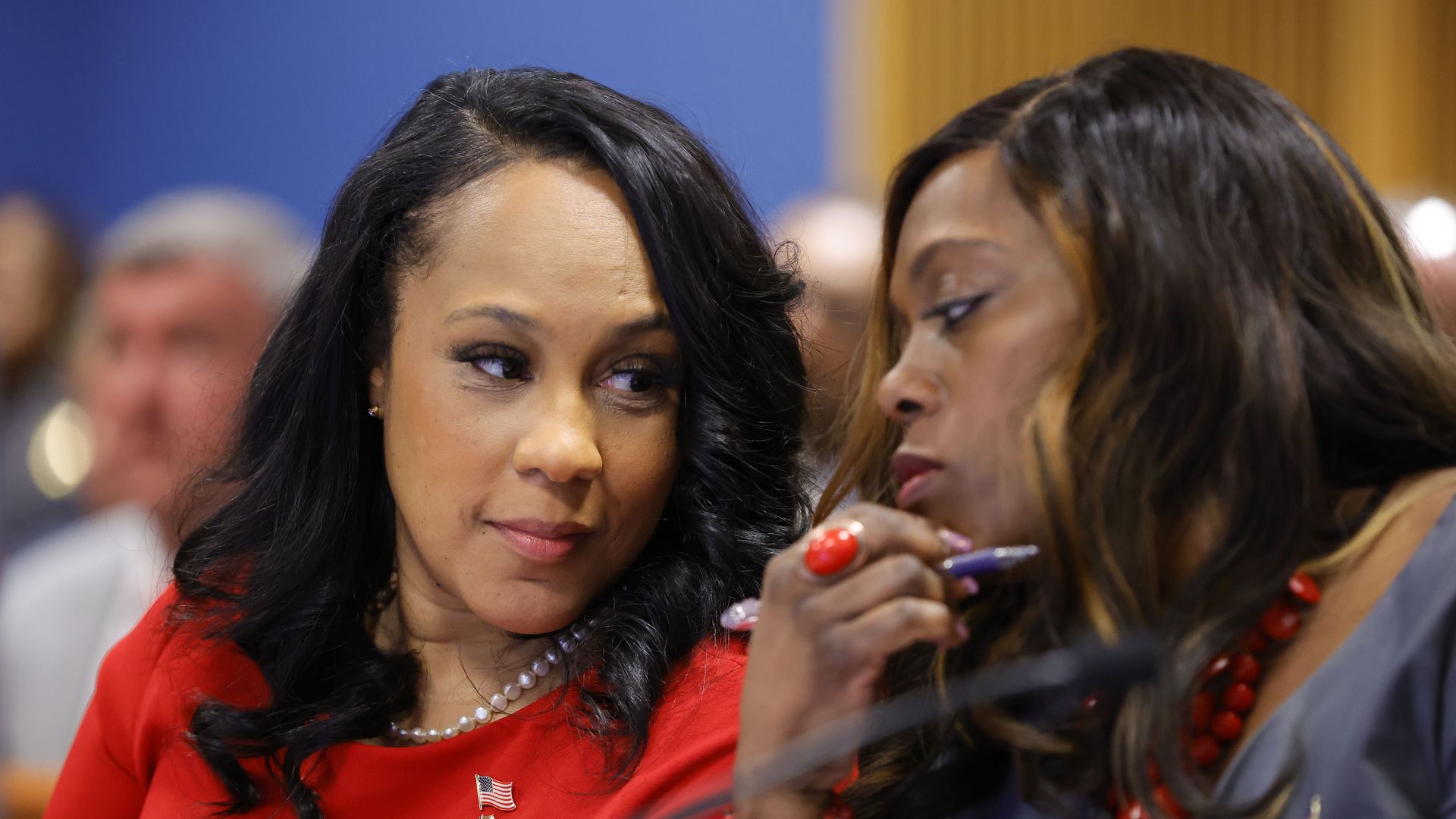 Fulton County District Attorney Fani Willis, left and prosecutor Daysha Young, right, speak to each other during a hearing at the Fulton County Courthouse on March 1, 2024, in Atlanta, Georgia.