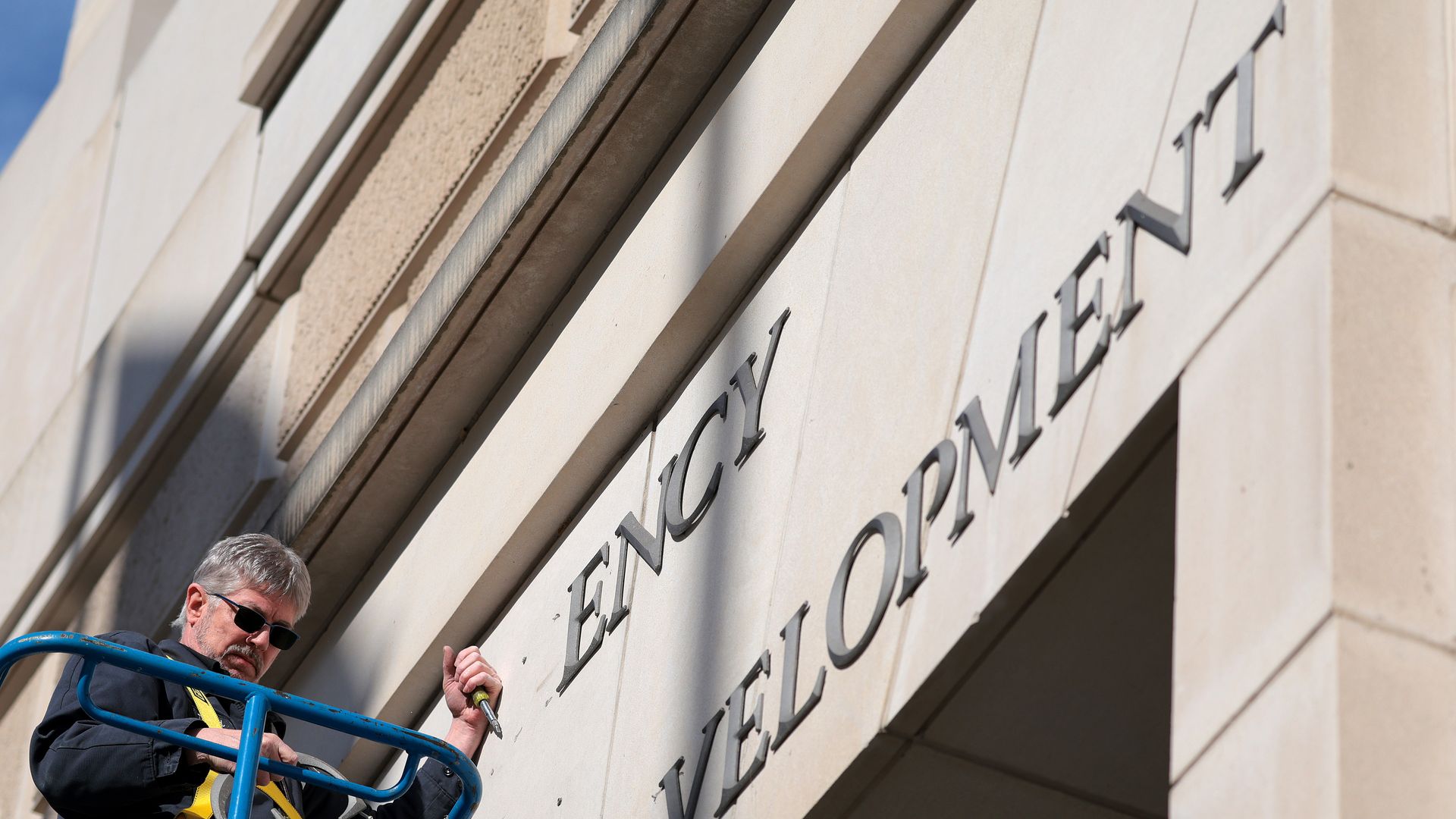 A worker removes the name of the U.S. Agency for International Development from the headquarters in Washington D.C.