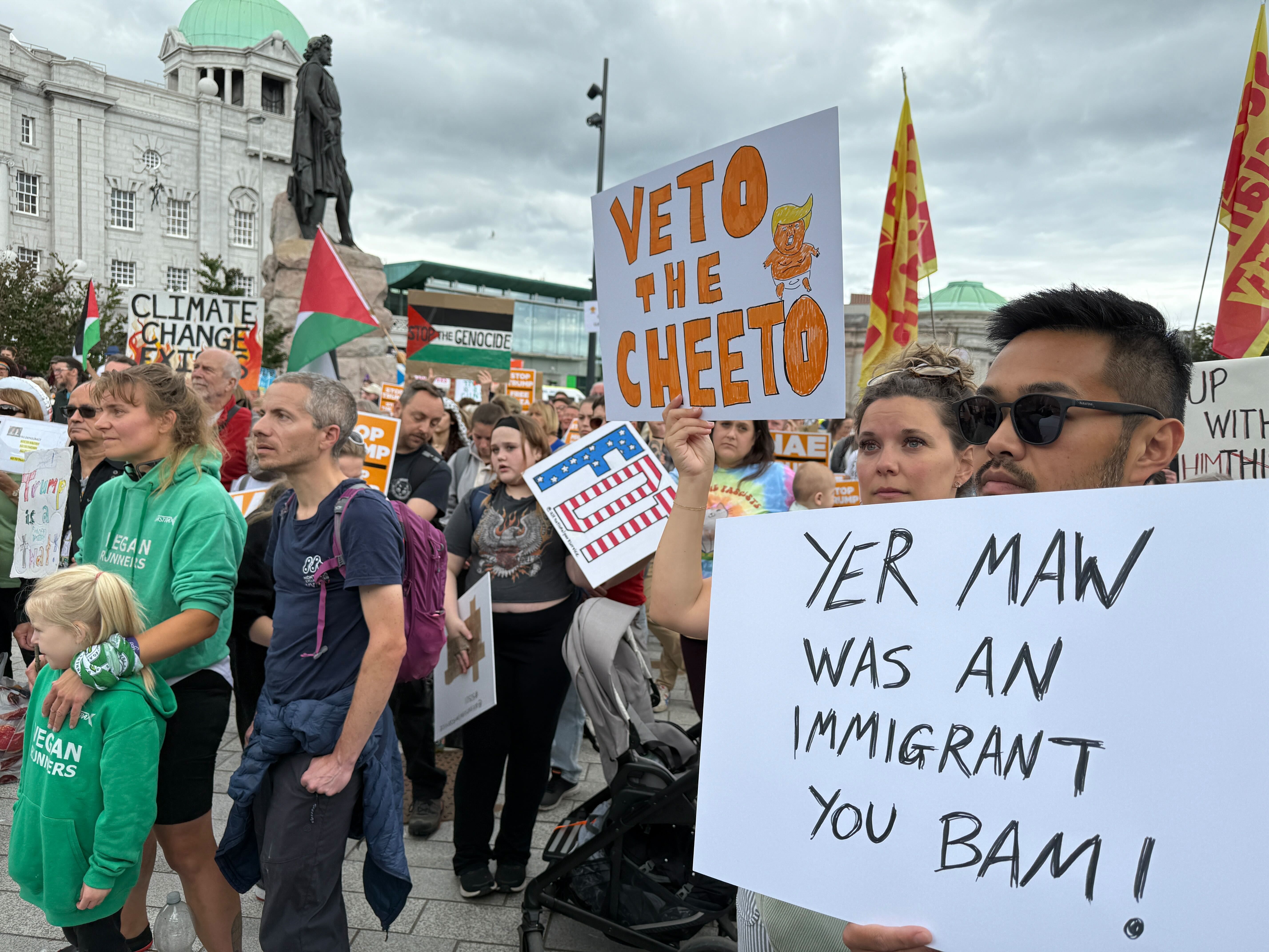 People hold signs with inscriptions such as "Yer Maw was an immigrant you bam!" (meaning "Your mother was an immigrant, you idiot!").