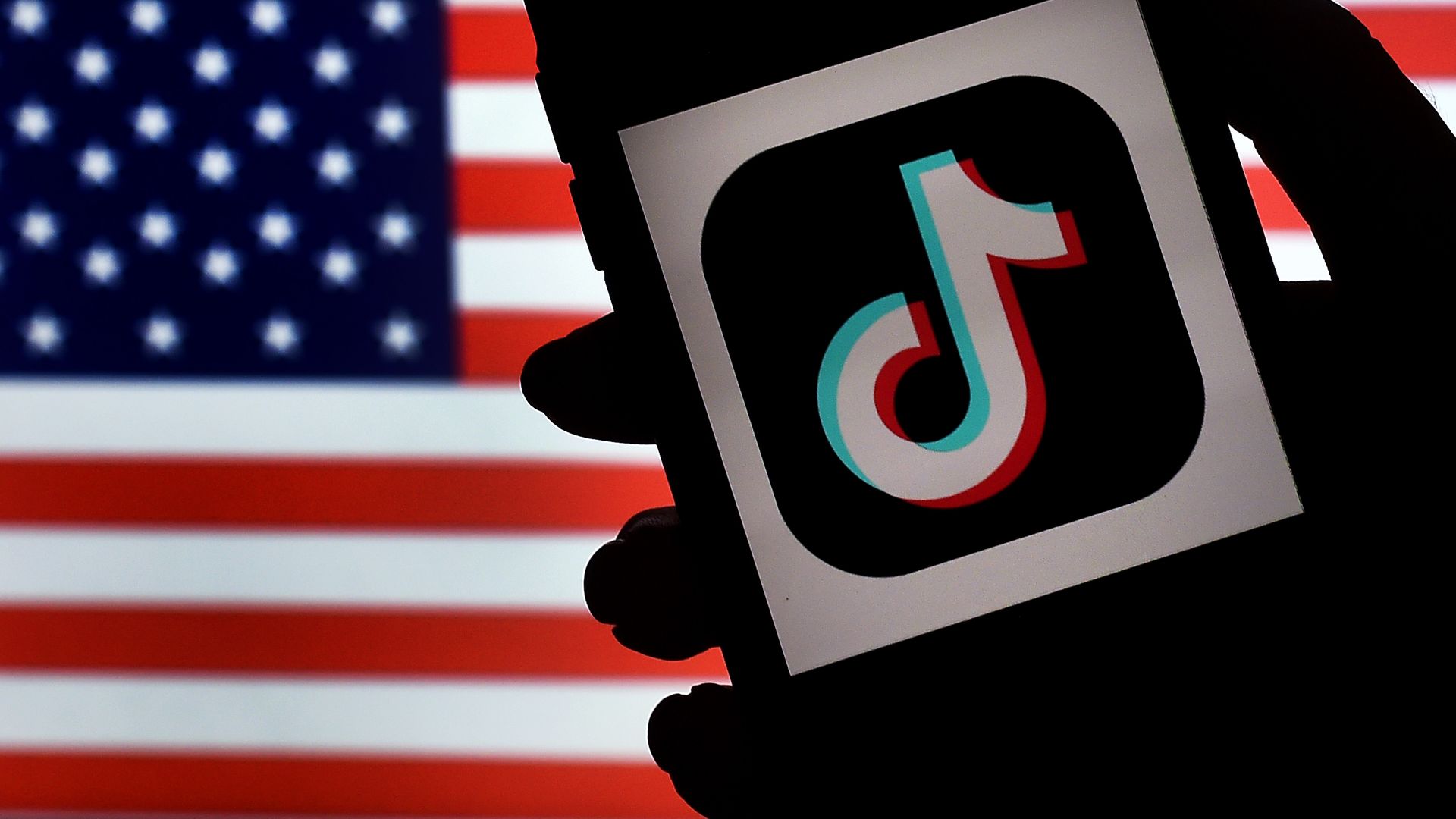 In this photo illustration, the social media application logo, TikTok is displayed on the screen of an iPhone on an American flag background on August 3, 2020 in Arlington, Virginia.