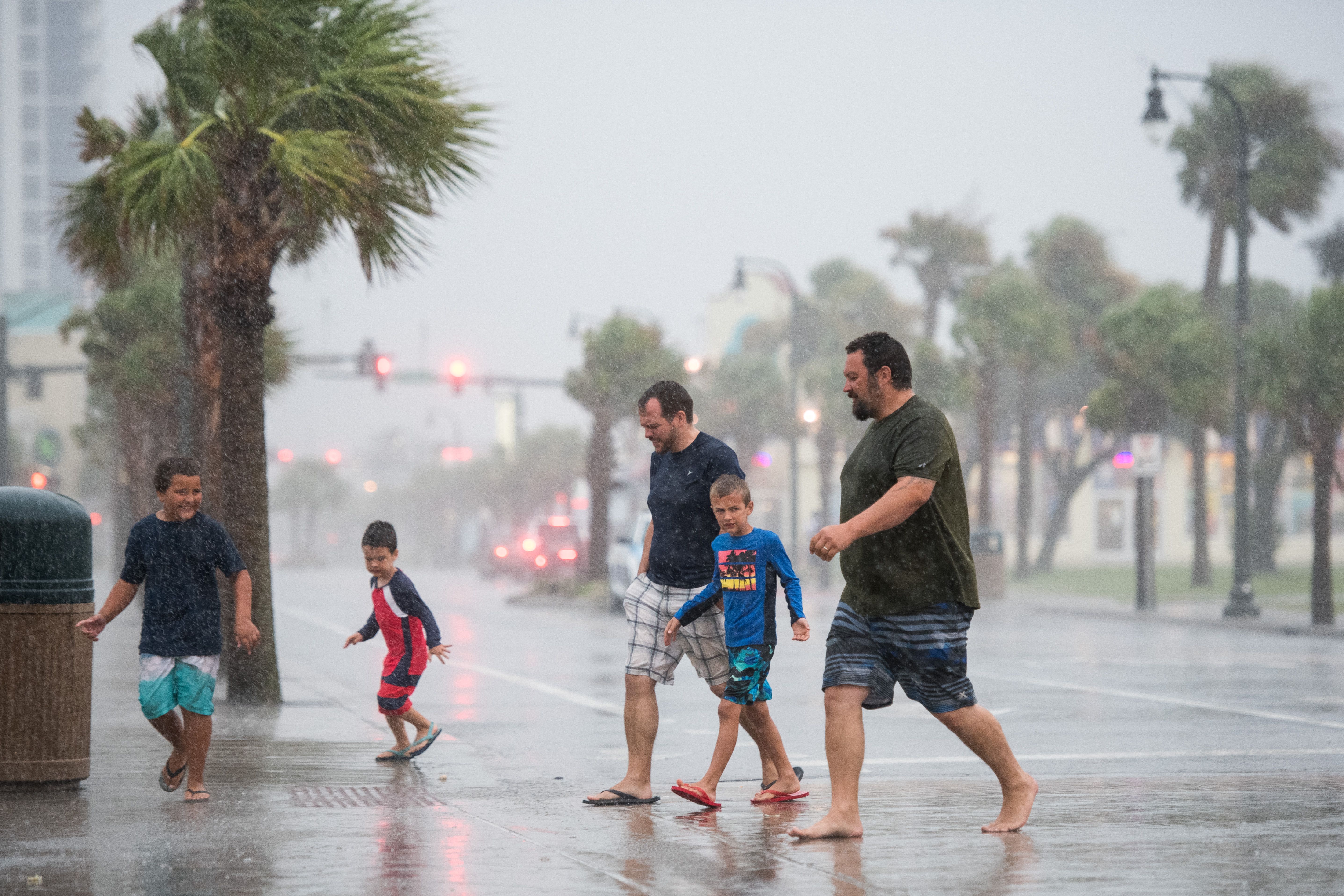 People walk across Ocean Boulevard in the rain August 3, 2020 in Myrtle Beach, South Carolina. 