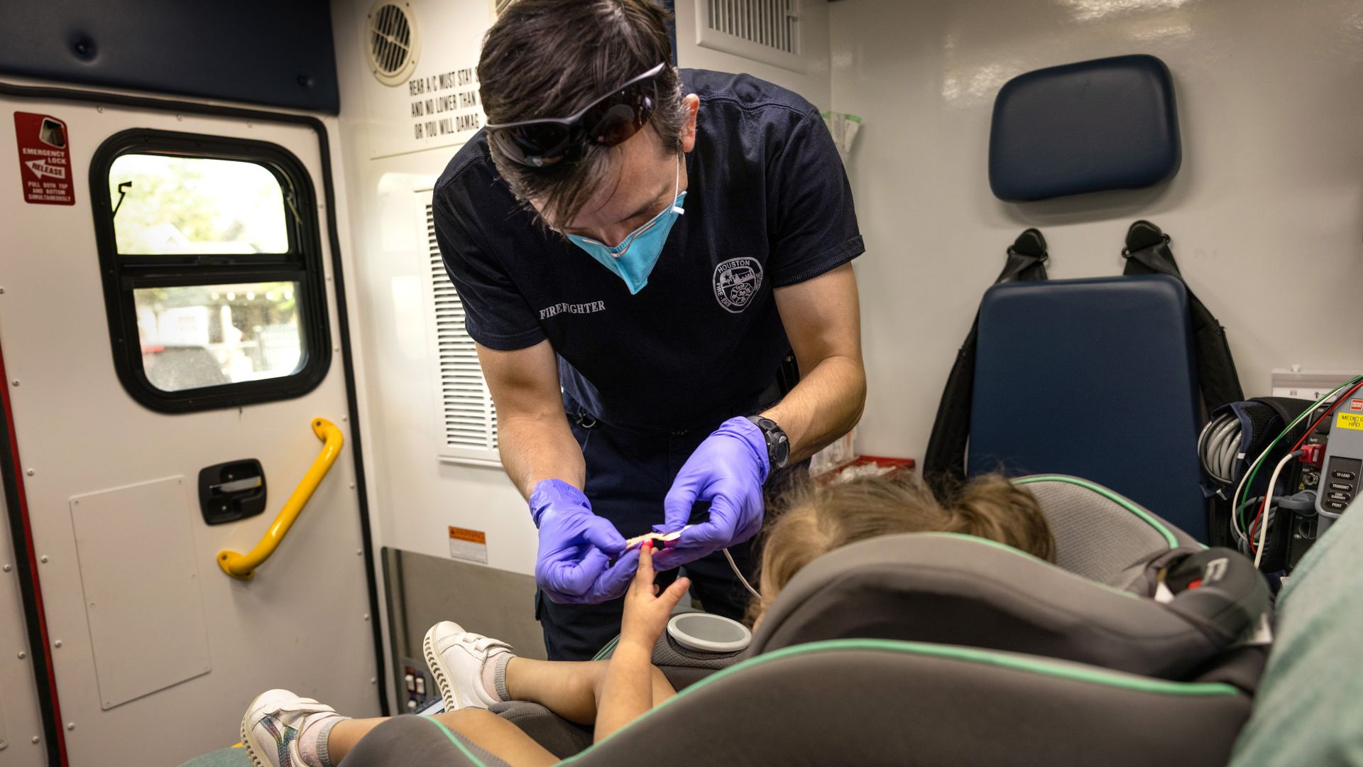 An EMS medic from the Houston Fire Department prepares to transport a Covid-19 positive girl, age 2, to a hospital on August 25, 2021 in Houston, Texas