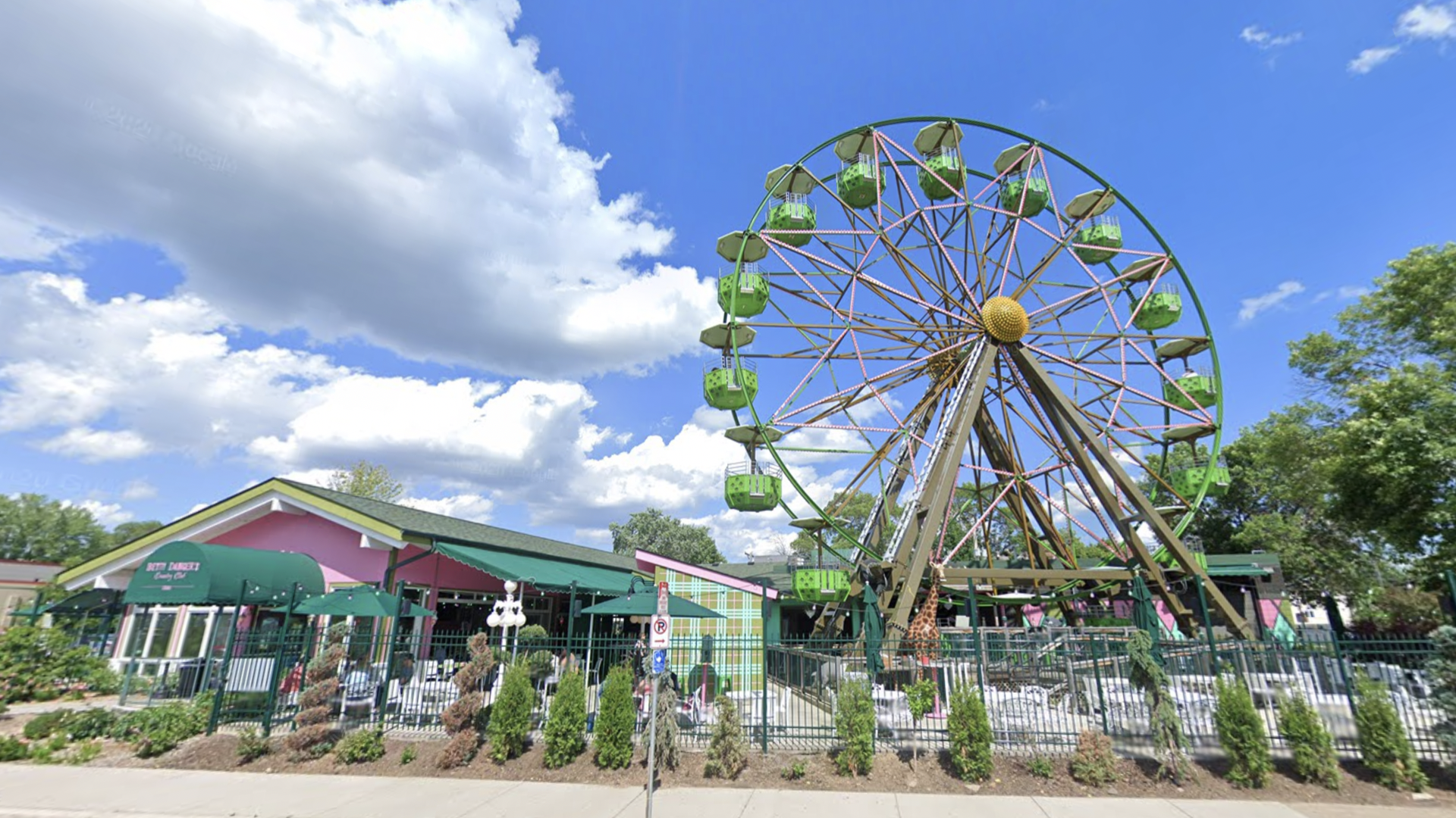 The Betty Dangers ferris wheel spins next to a restaurant