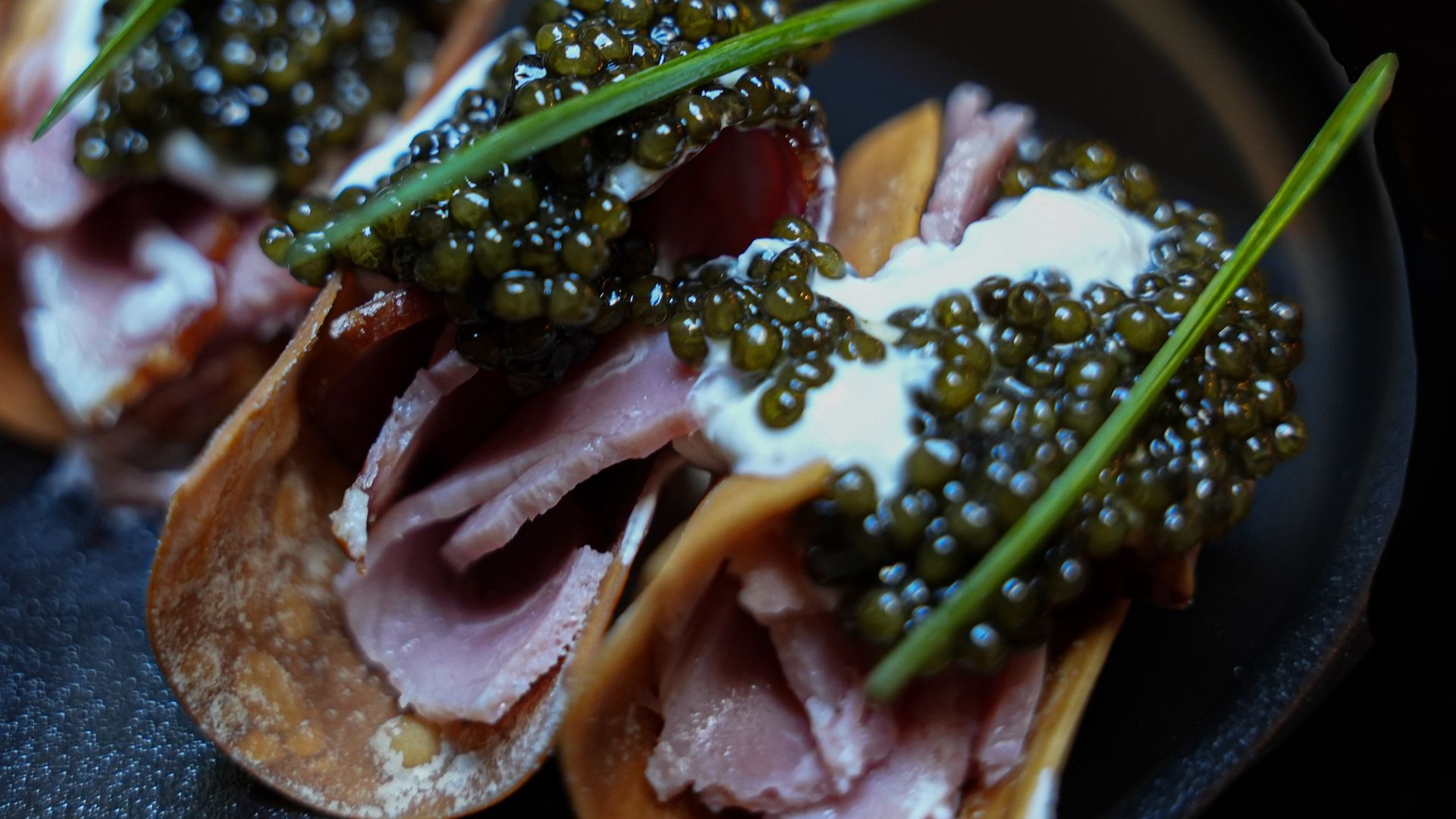 Iberico ham on crispy wontons, topped with crème fraîche, caviar and chives.