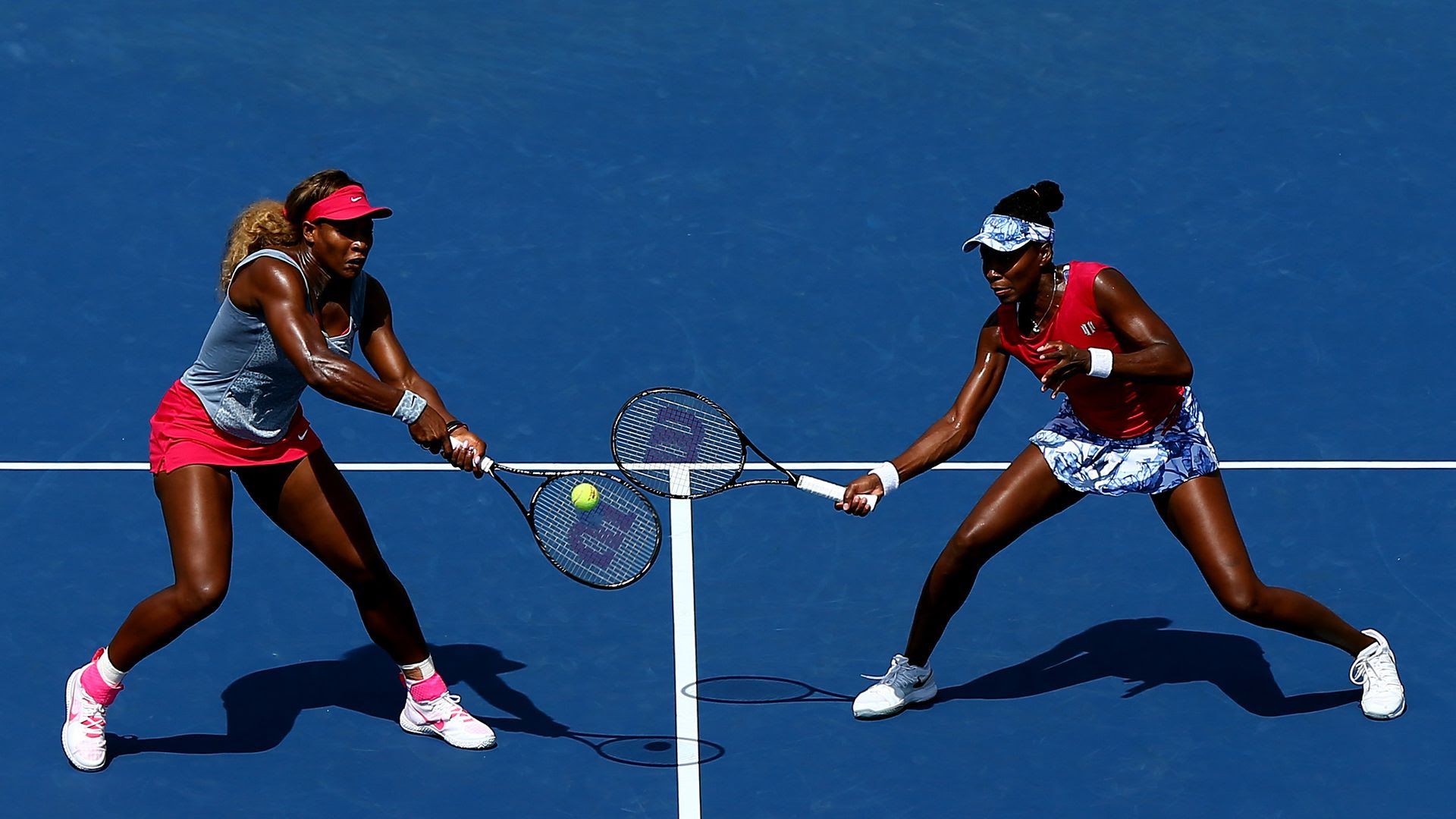 Venus and Serena Williams playing tennis.