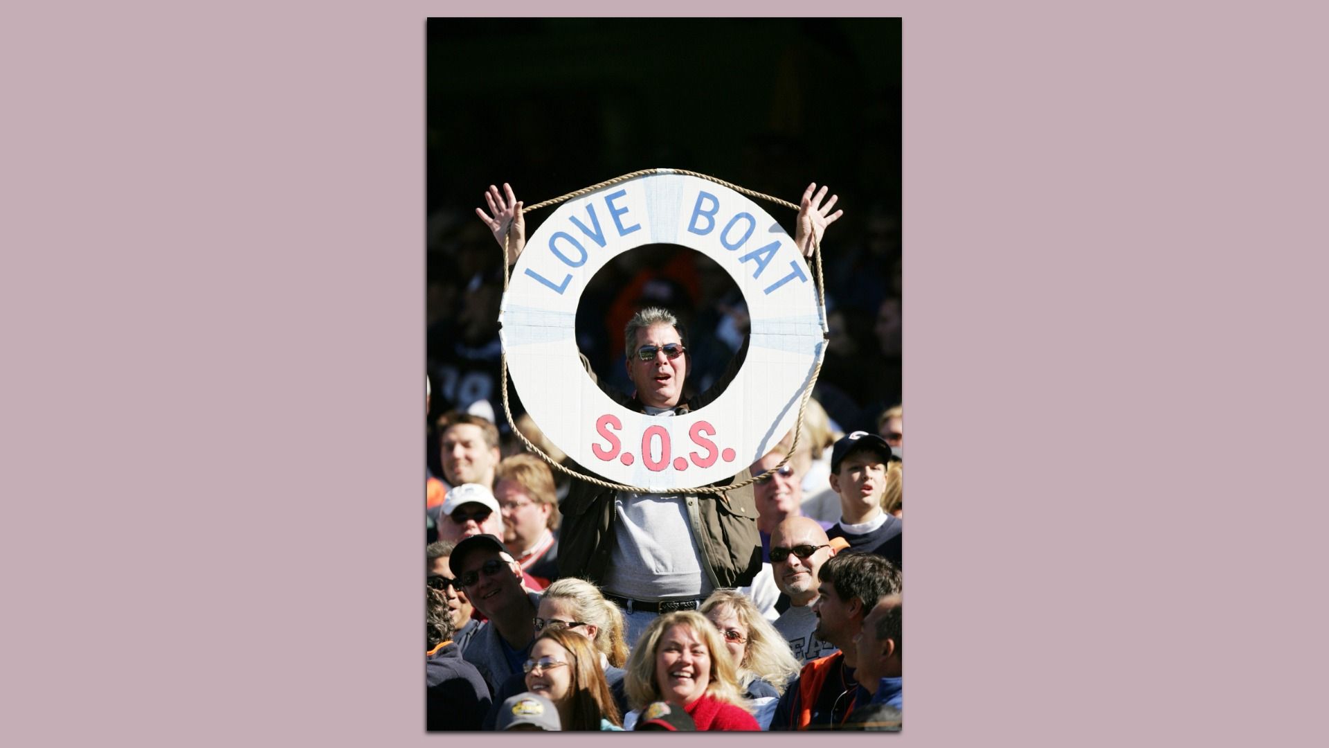 A man holds a Love Boat SOS sign