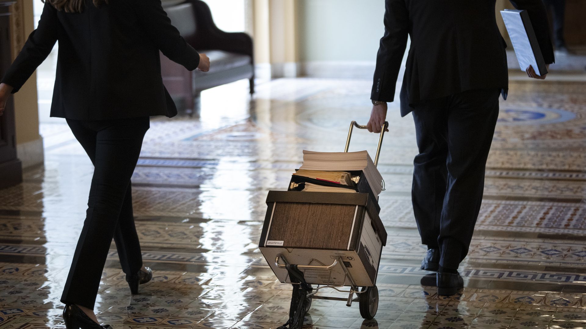 Congressional aides carry paperwork. 