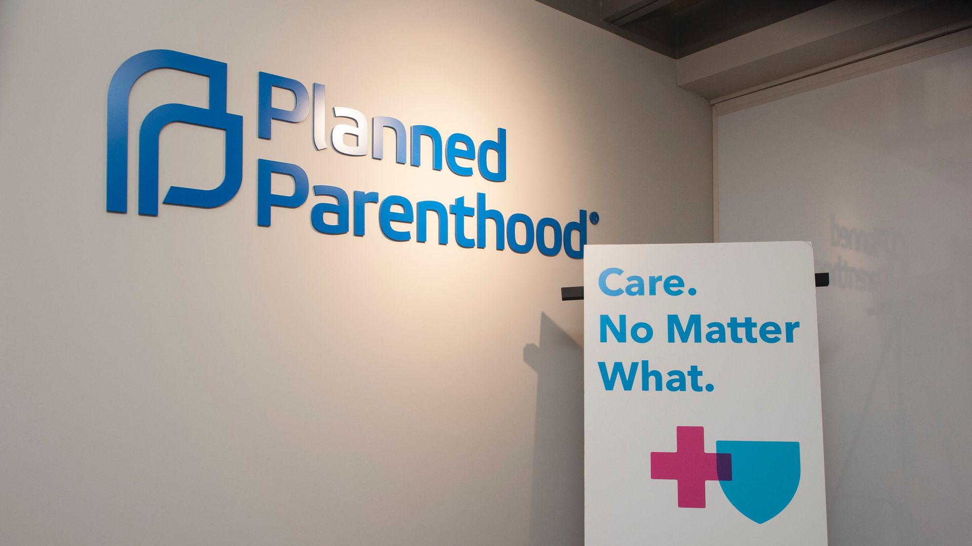A sign that says "Planned Parenthood" and another that says "Care. No Matter What." 
