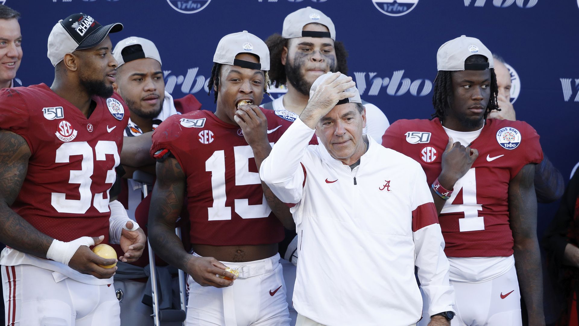 Nick Saban stands with Alabama football players`