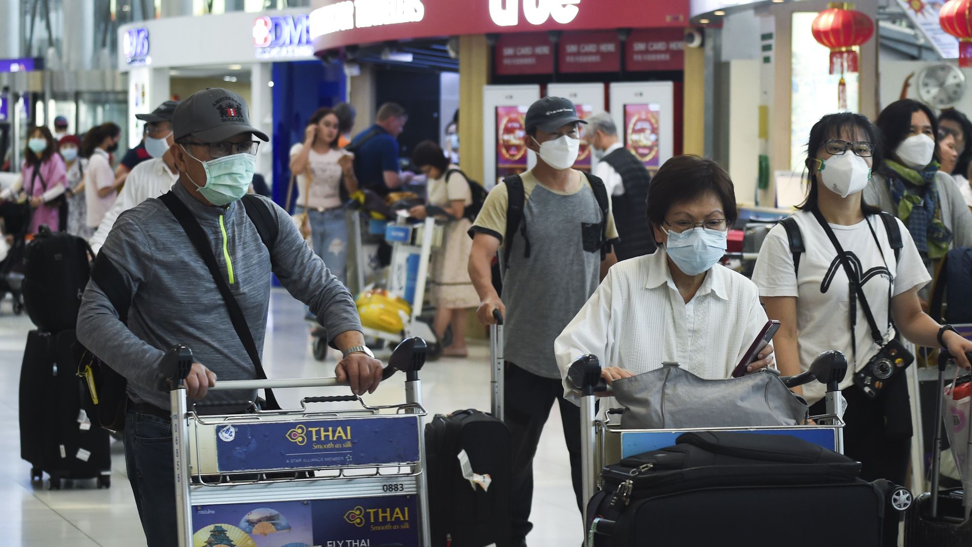 People wearing surgical masks at an airport.