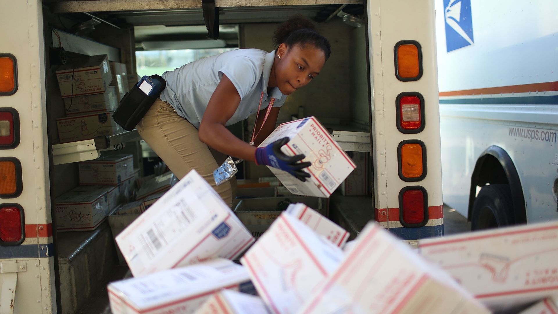 Postal employee unloading boxes