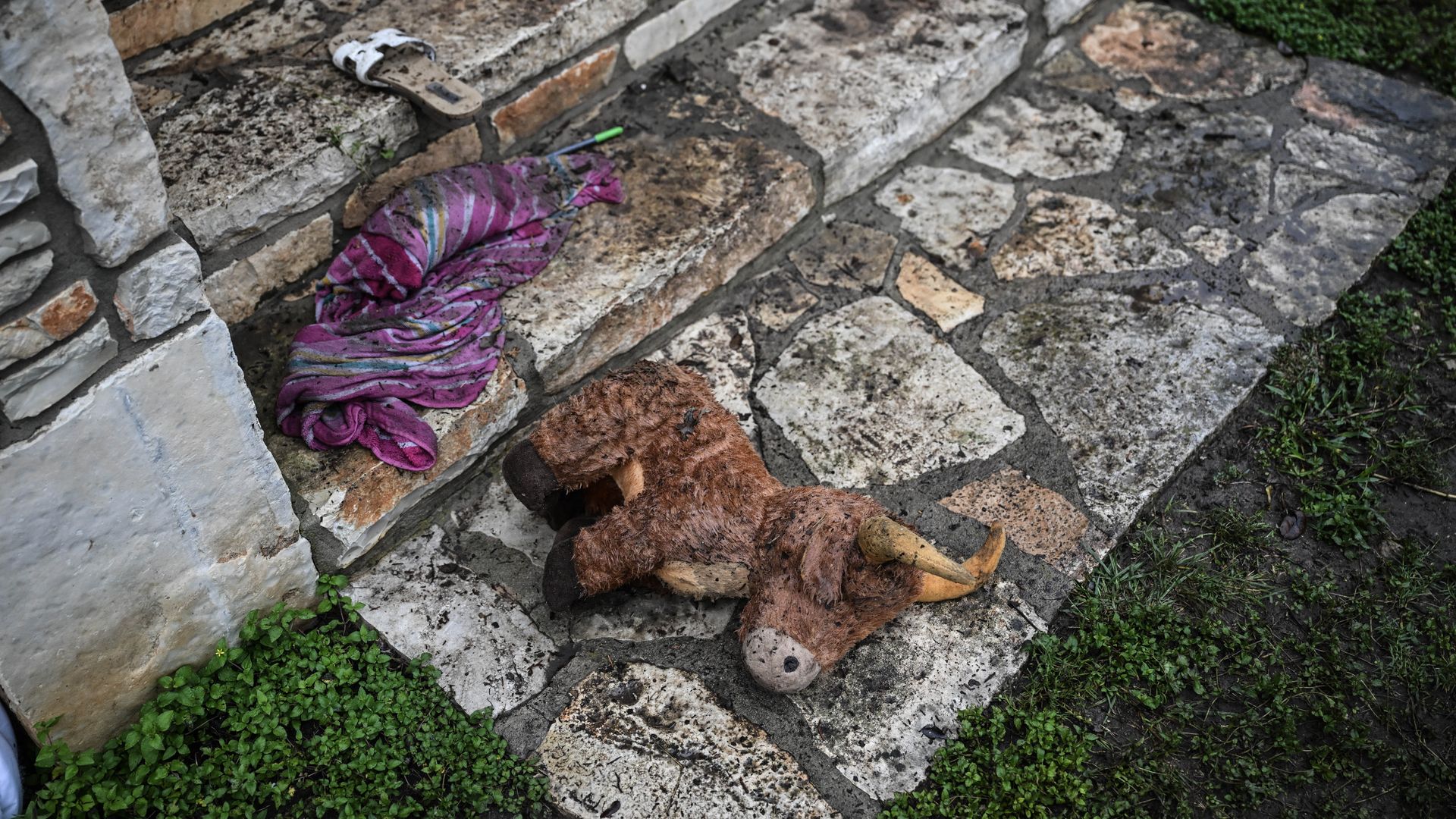 A wet stuffed animal lays on the ground after flooding in Texas