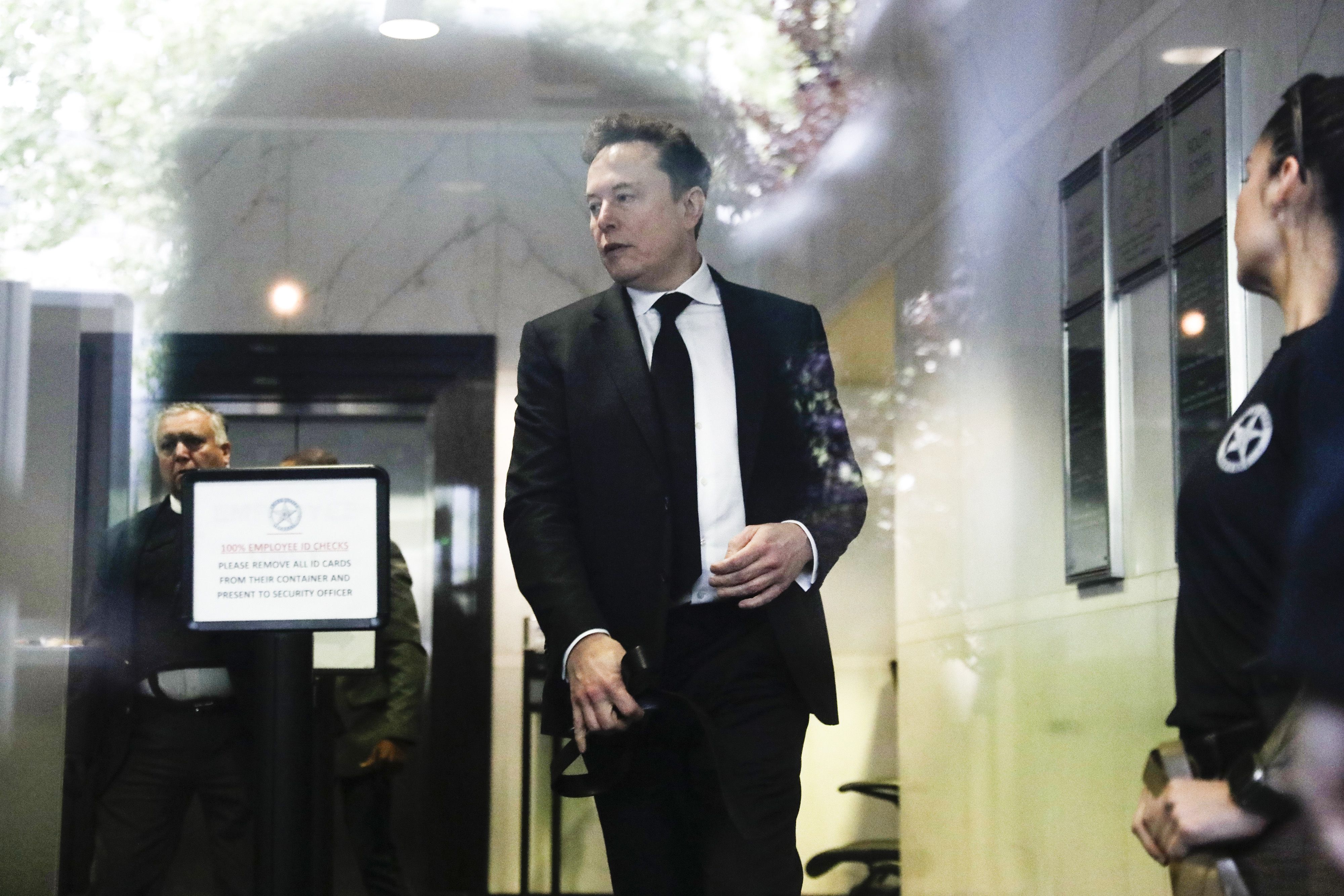Elon Musk arrives at a federal courthouse in Oakland, Calif., yesterday. 