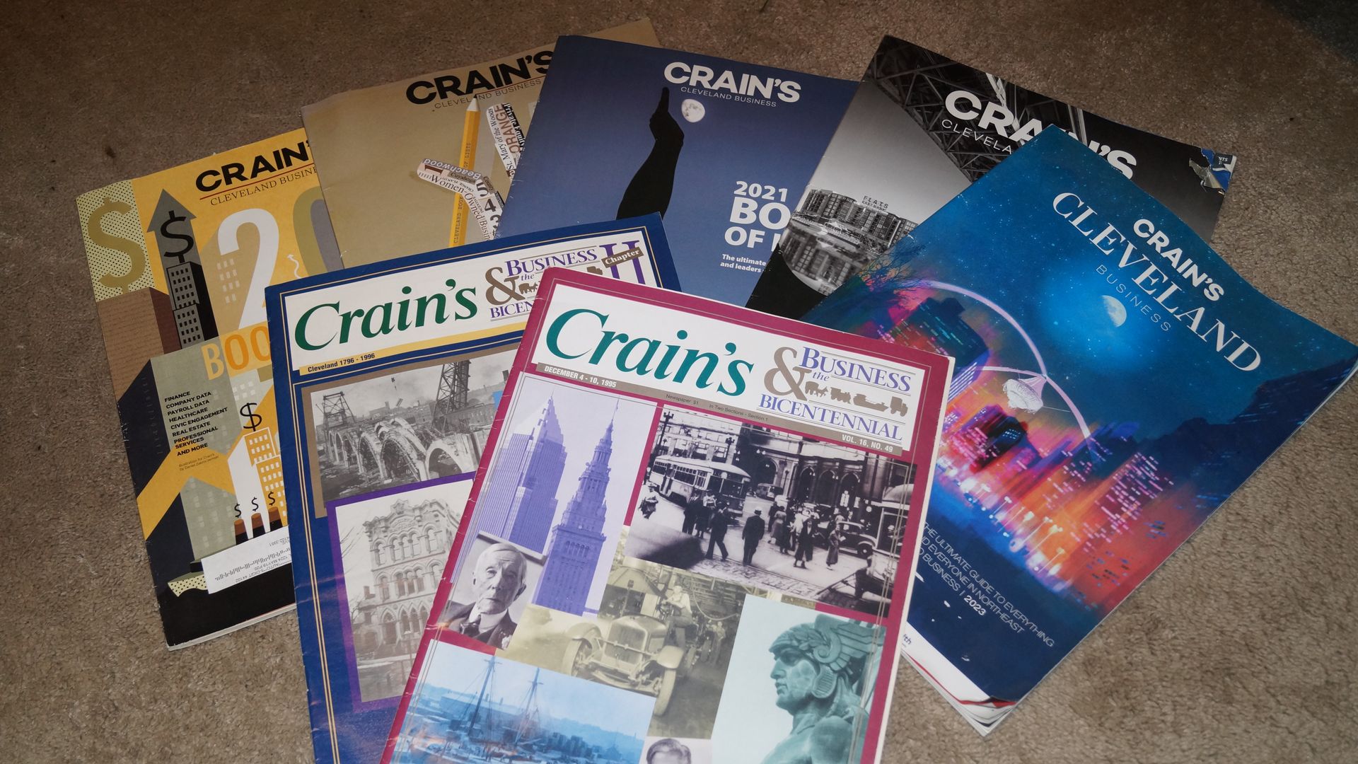 An array of Crain's Cleveland Business magazines on a beige carpeted floor 