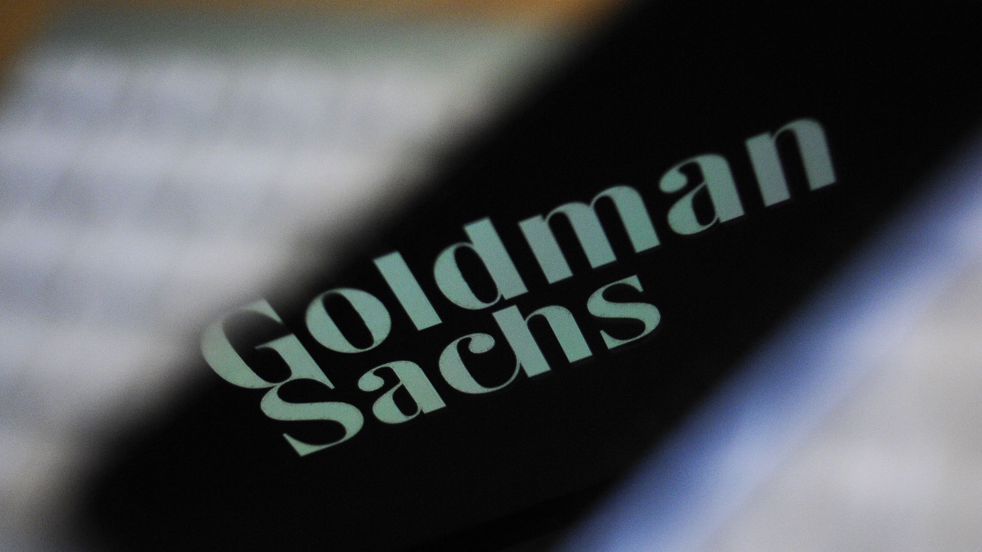 The Goldman Sachs bank logo is seen reflected on the screen of a mobile phone.