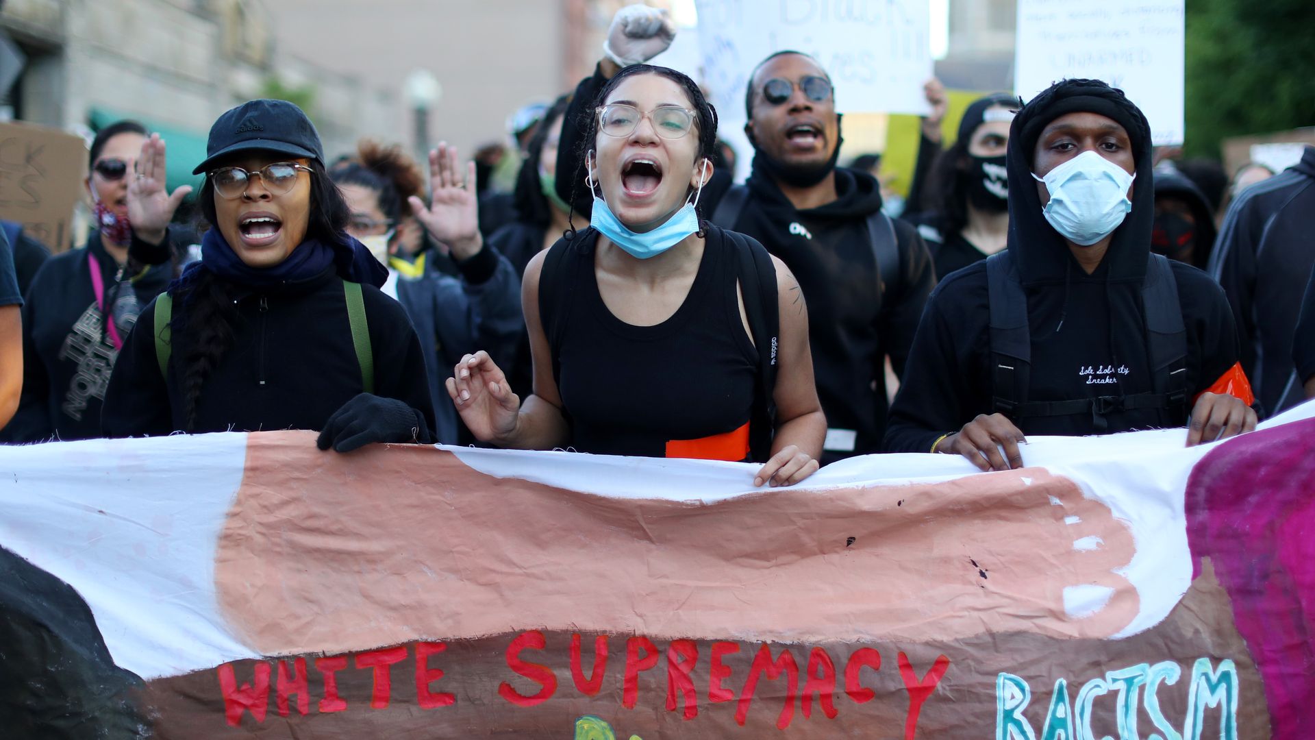 Protestors, including some without masks or with their masks pulled down