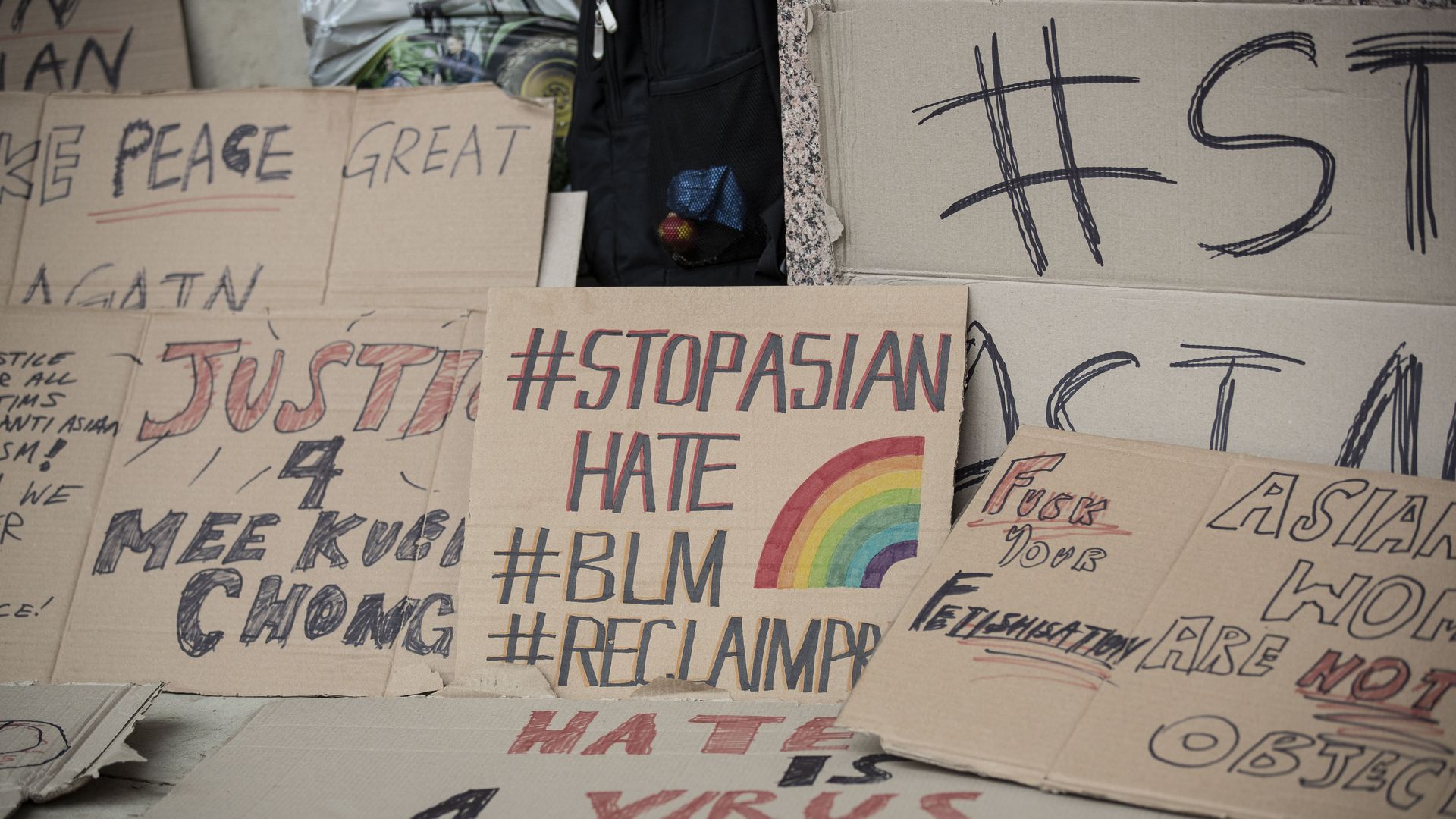 Signs from a protest with slogans like "BLM" and "Stop asian hate"
