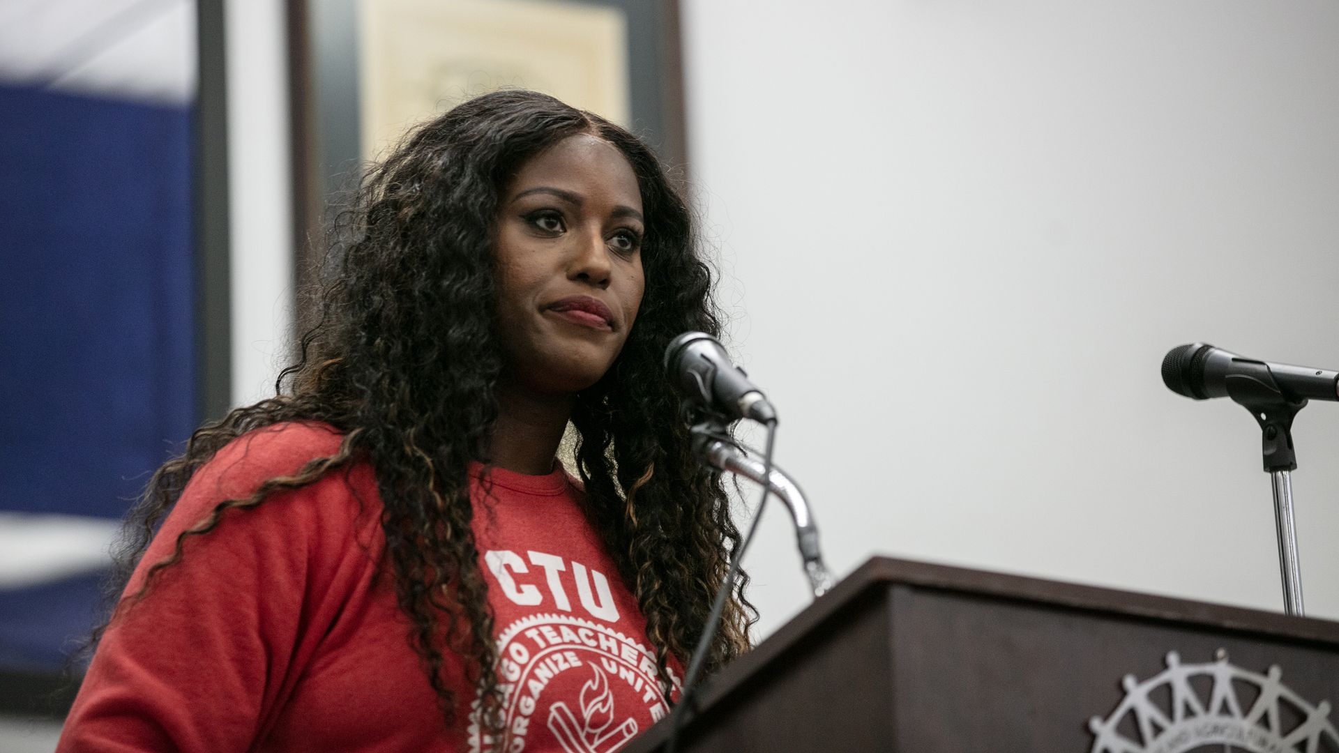 Photo of a woman behind a podium speaking to a crowd. 