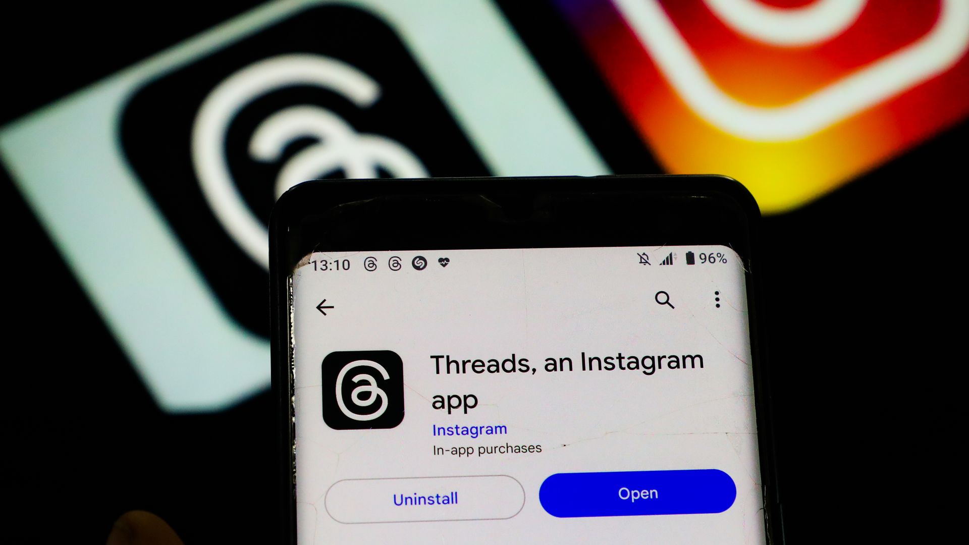 Photo of a phone with the Threads logo and Instagram lol 