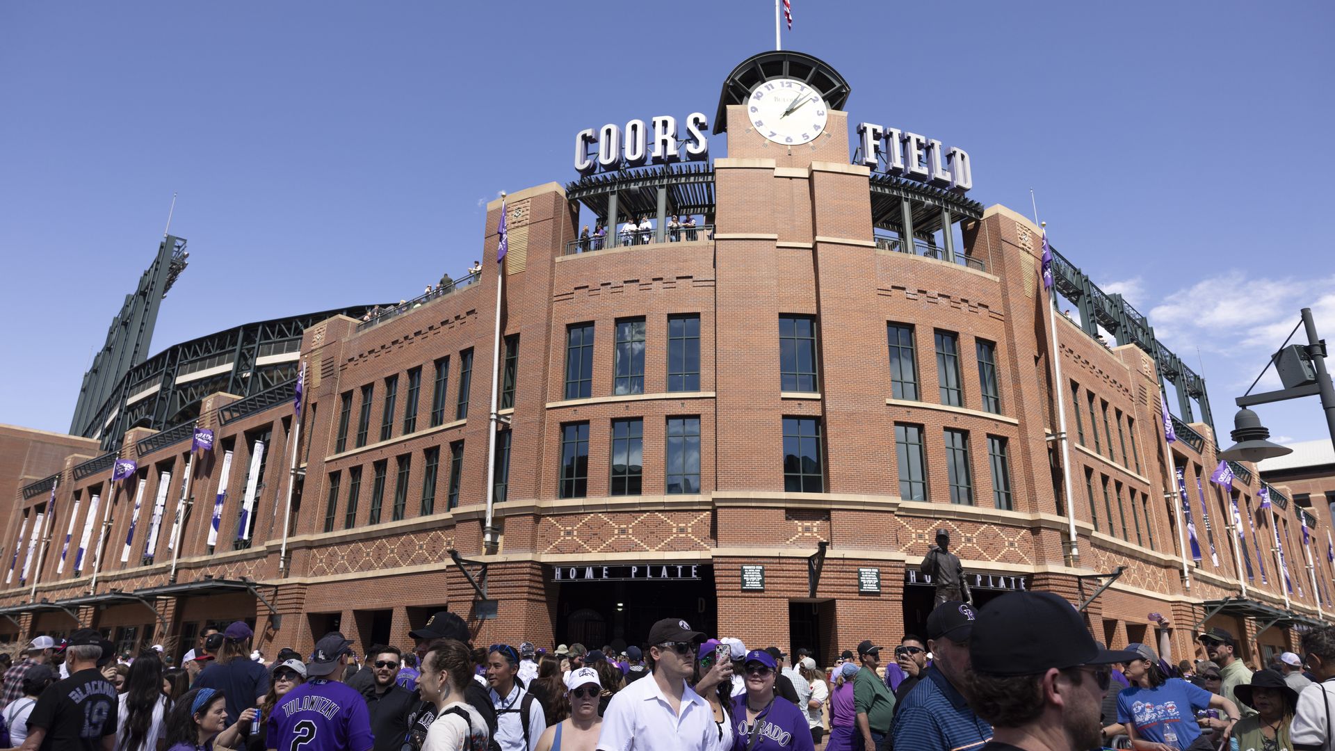 A photo of Coors Field with fans walking around.