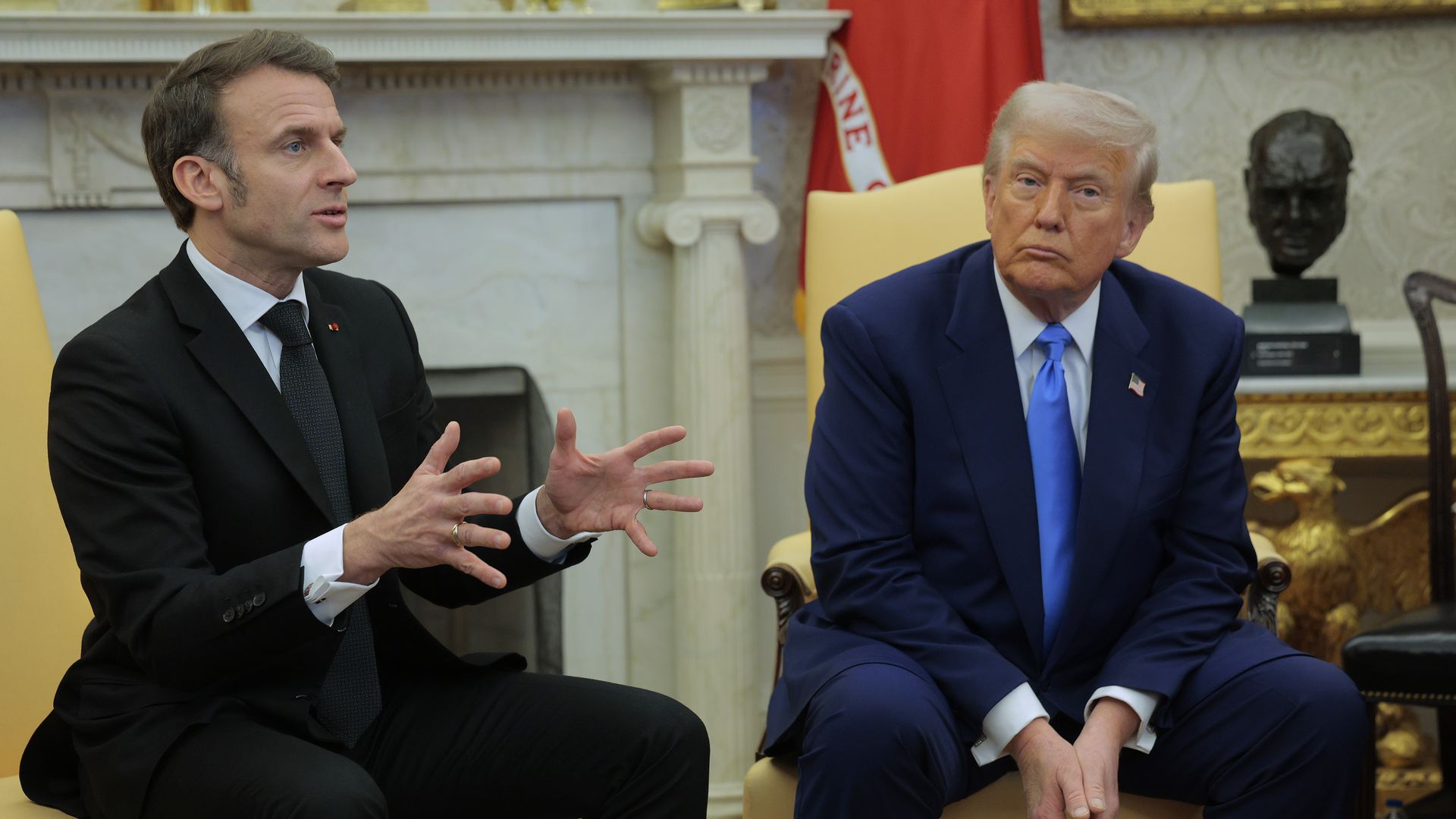 Donald Trump listens as French President Emmanuel Macron answers a reporter's question in the Oval Office at the White House on February 24,