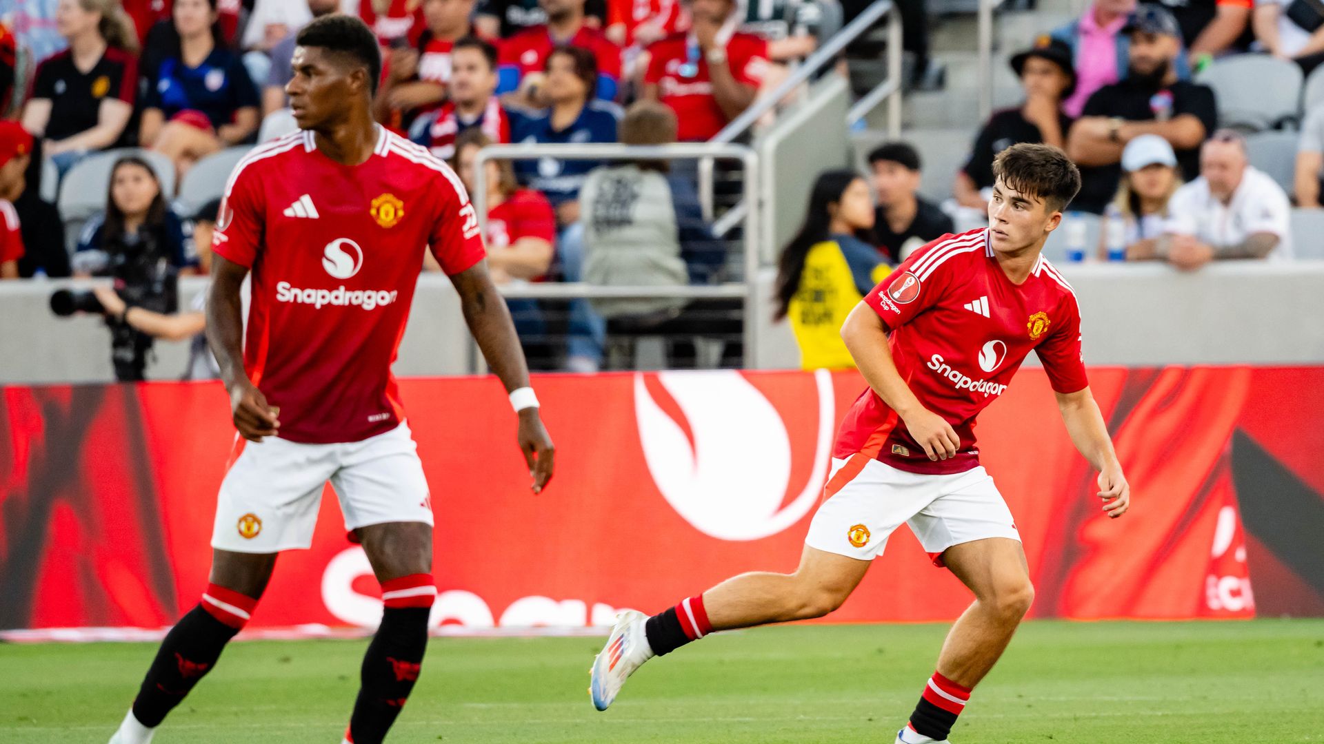 Two Manchester United soccer players running on the field. 