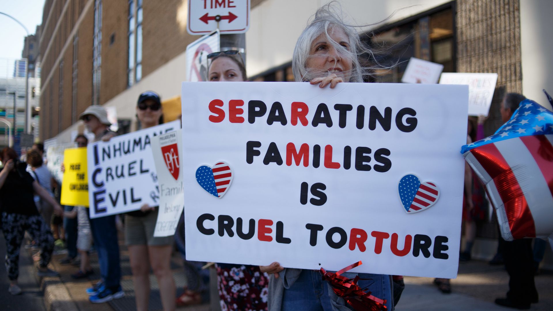 People holding up signs in protest of separation of families at the border.