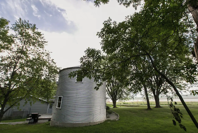 A grain bin that's been converted into an Airbnb sits on a farm.