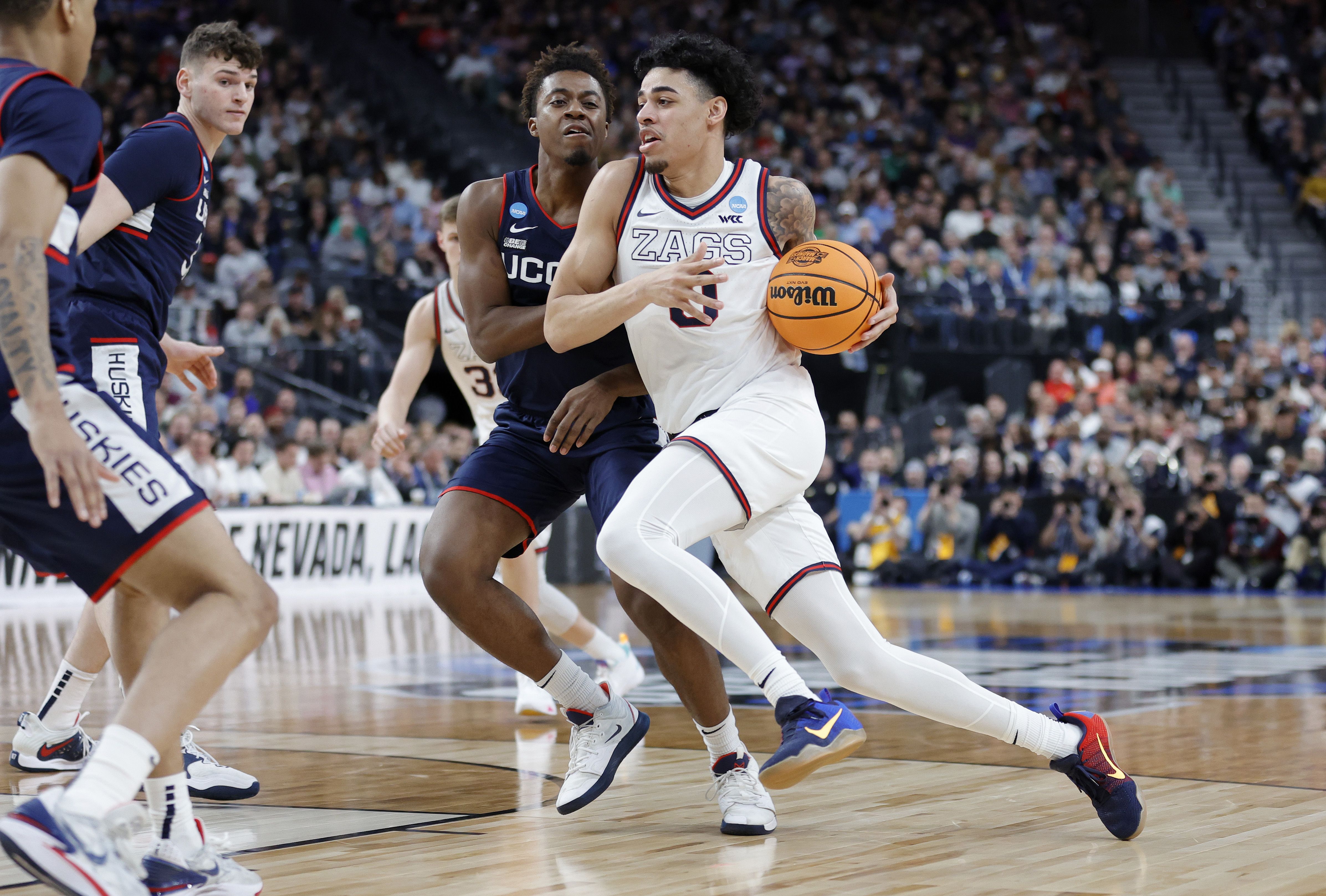 A man drives up to the basket while holding a ball.